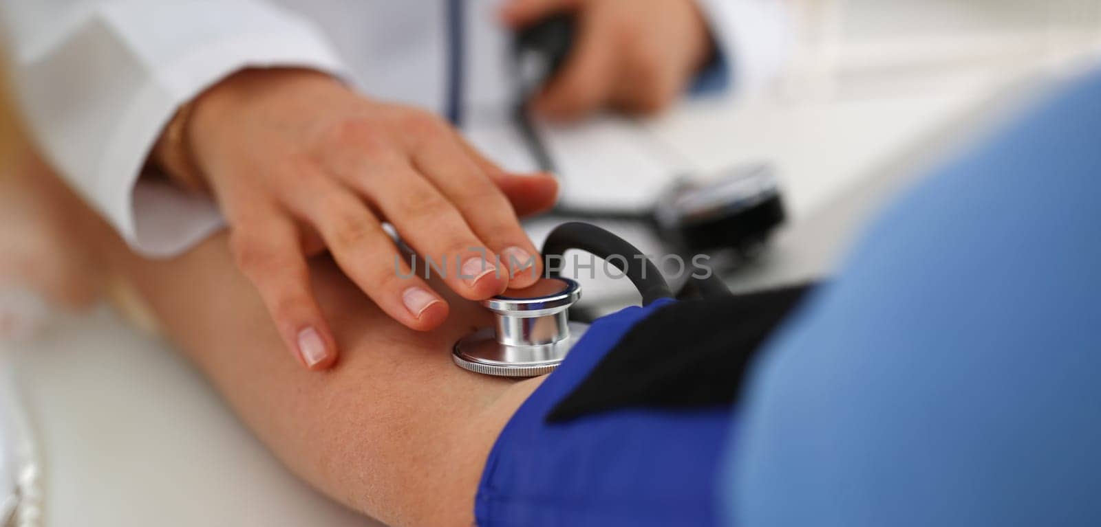 Close-up of nurse measure blood pressure with tonometer tool in clinic. Patient on appointment, help people. Medicine, science, diagnostic, checkup concept