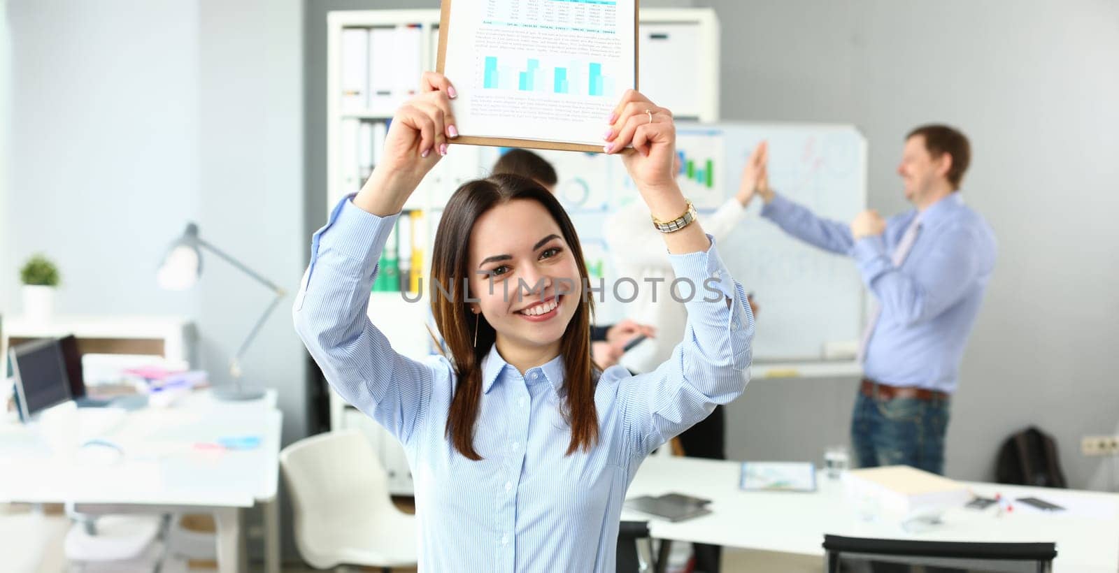 Portrait of woman lift document over head, celebrate good deal, beneficial agreement. Well done, good job, startup, teamwork, success, work party concept