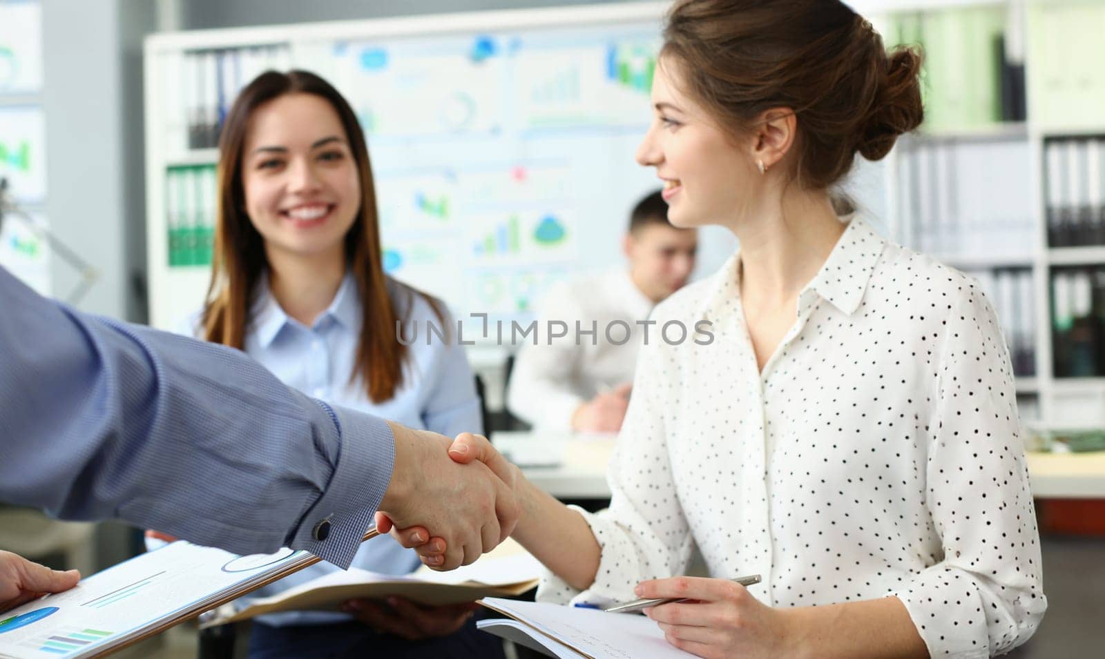 Portrait of people get to know each other in new group, shake hands over business papers. Greeting new worker in office. First day, intern, new job concept