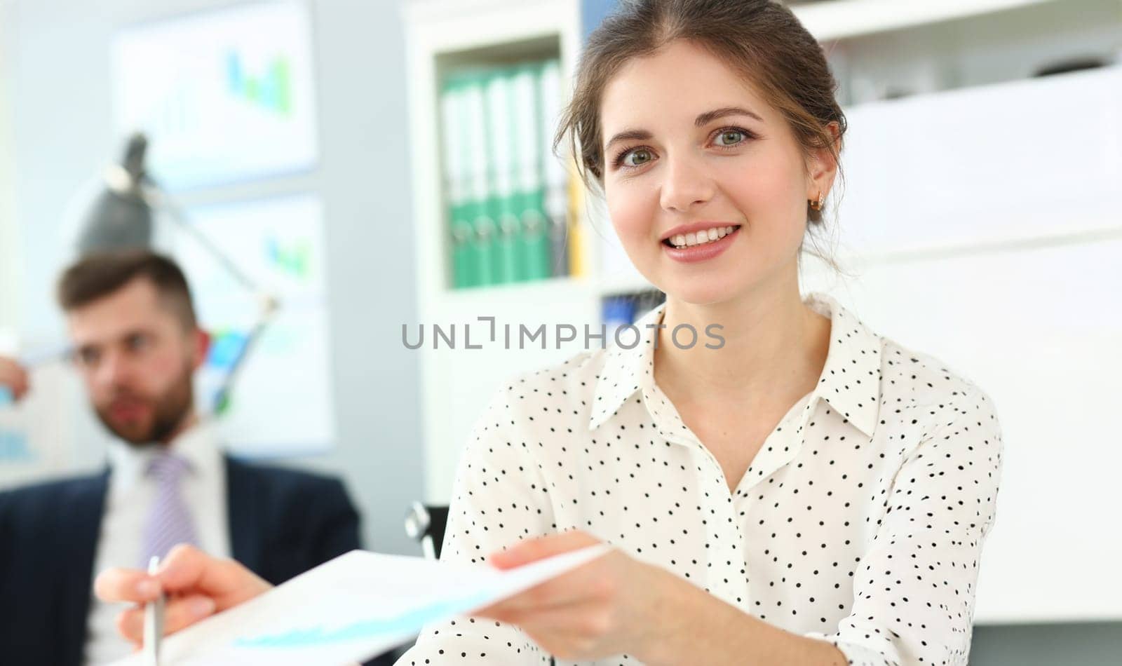Portrait of manager give paper to boss to sign, good secretary, reliable worker. Brunette clerk work in friendly collective. Business, office life concept