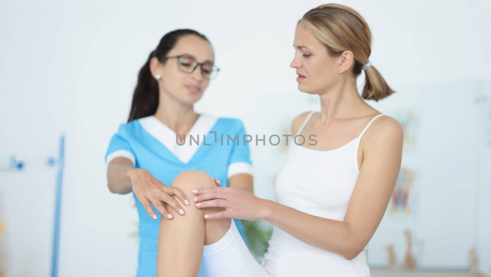 Portrait of physiotherapist give advice to female patient, rehabilitation after injury or accident. Physical therapy, recovery, healthcare, clinic concept