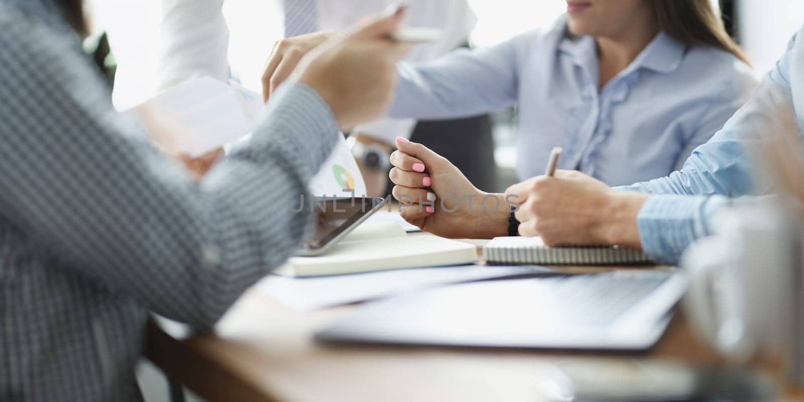 Close-up of coworkers discussing working moments and checking financial report in conference room. Business meeting and paper mess. Business, plan concept