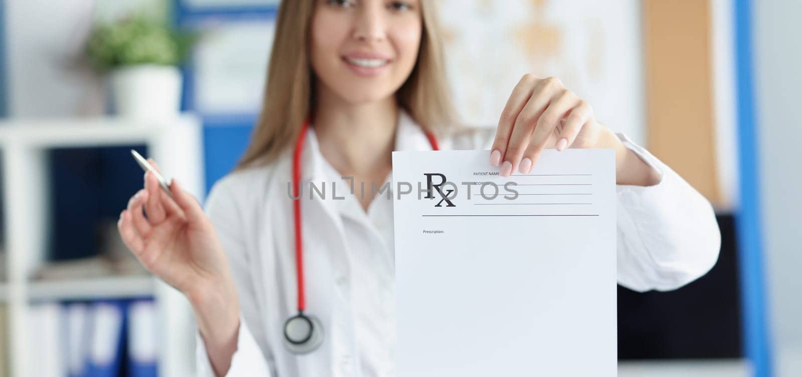 Portrait of smiling woman doctor hold prescription recipe in one hand and pen in another. Prescription paper for patient. Medicine, checkup, clinic concept