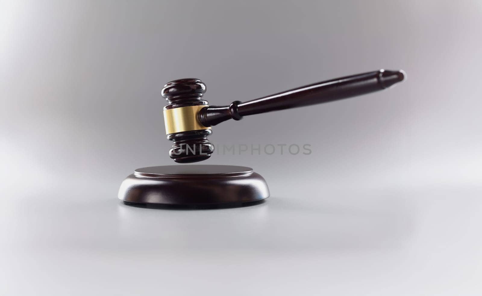 Close-up of judges wooden hammer on soundboard placed grey background. Attorney tool for legal service. Court, law, verdict, legality and justice concept