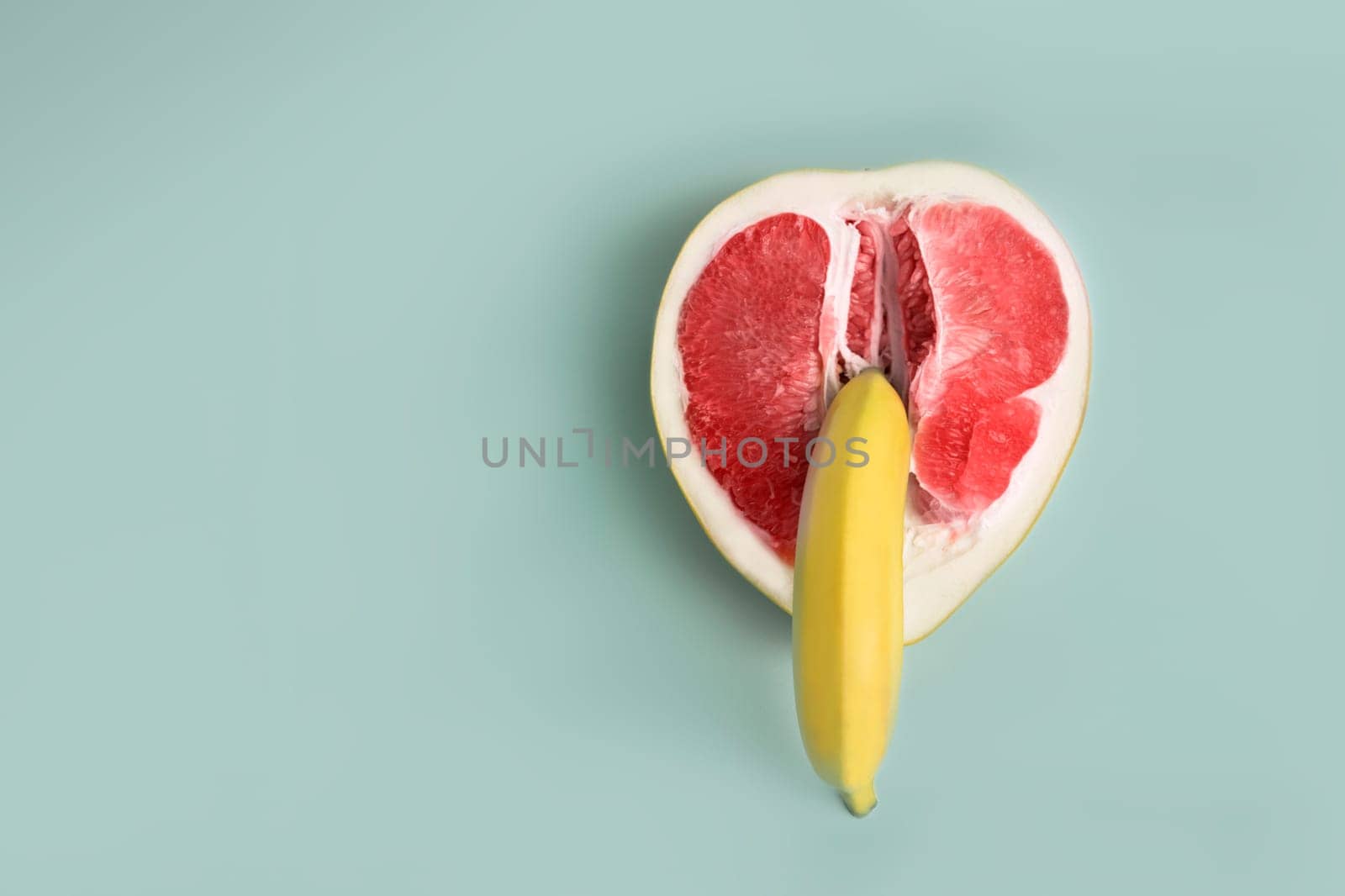 Banana and grapefruit flat lay minimal composition . A metaphor of sex, sexuality, vagina and penis.