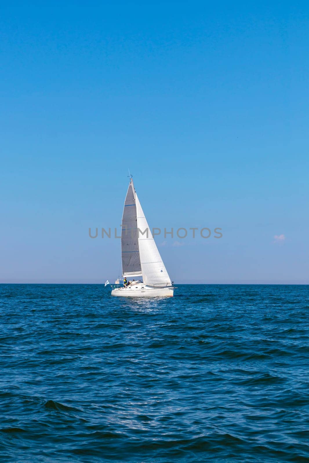 Yacht, white sailboat under head genoa and main sails sailing in an calm open sea. Cruise, vacations, regatta, sport. Gulf of Finland