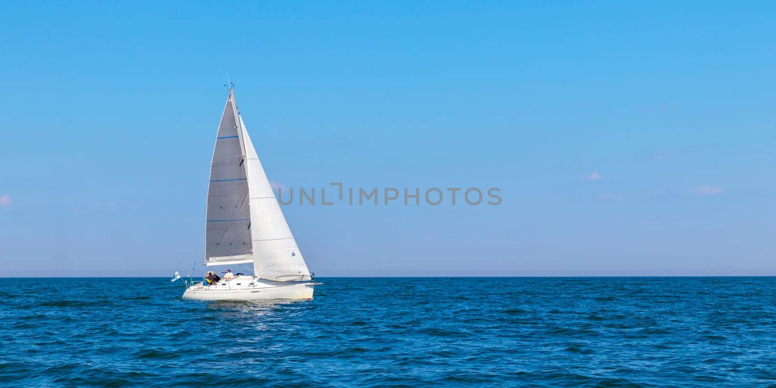 Yacht, white sailboat under head genoa and main sails sailing in an calm open sea. Cruise, vacations, regatta, sport. Gulf of Finland