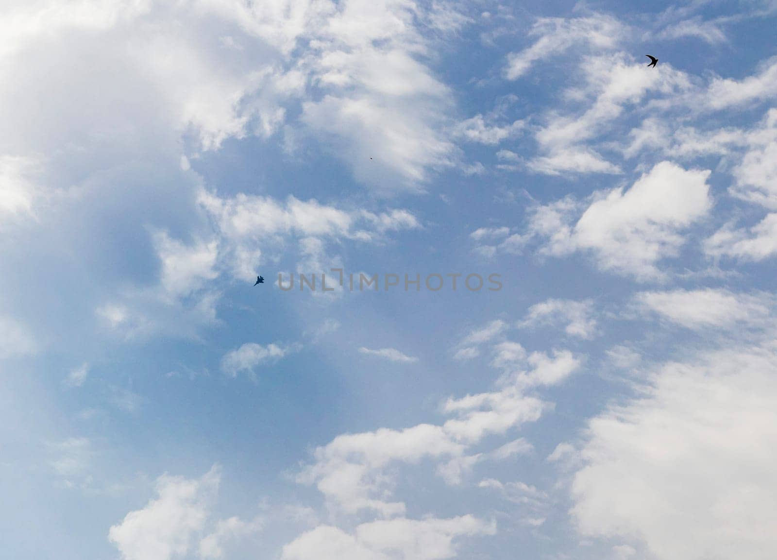 Silhouette of the MIG fighter jet in the cloudy sky