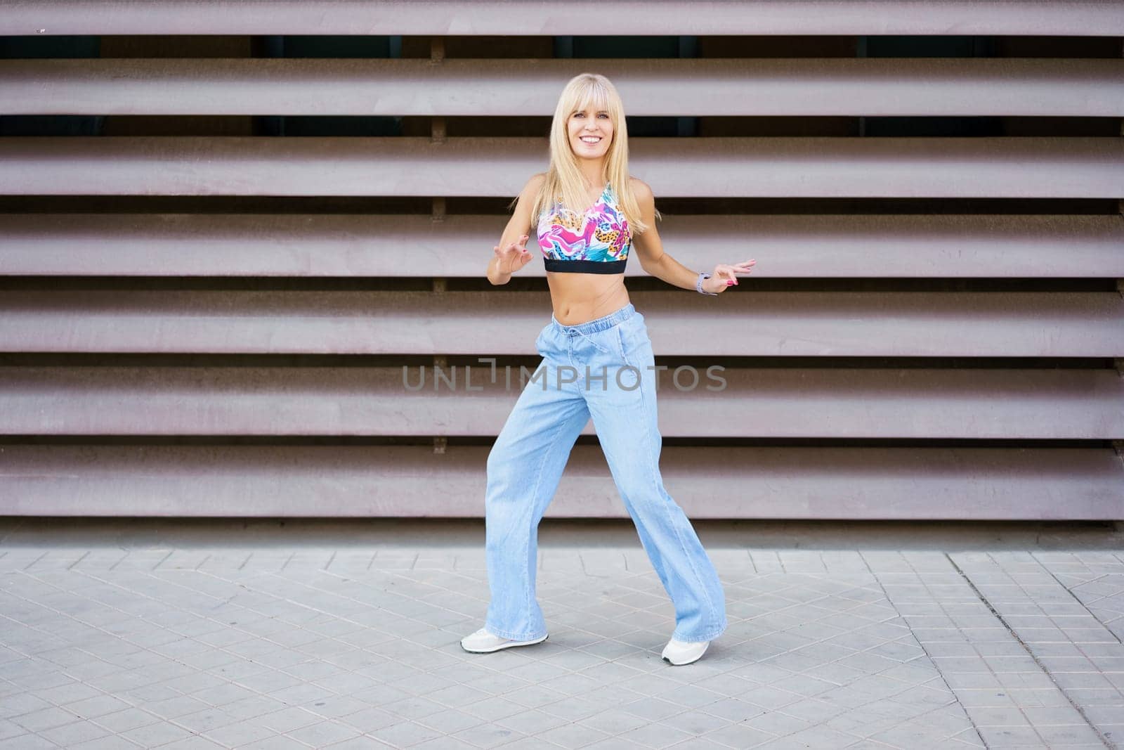 Frontal full length of a young blonde female dancer performing in the street