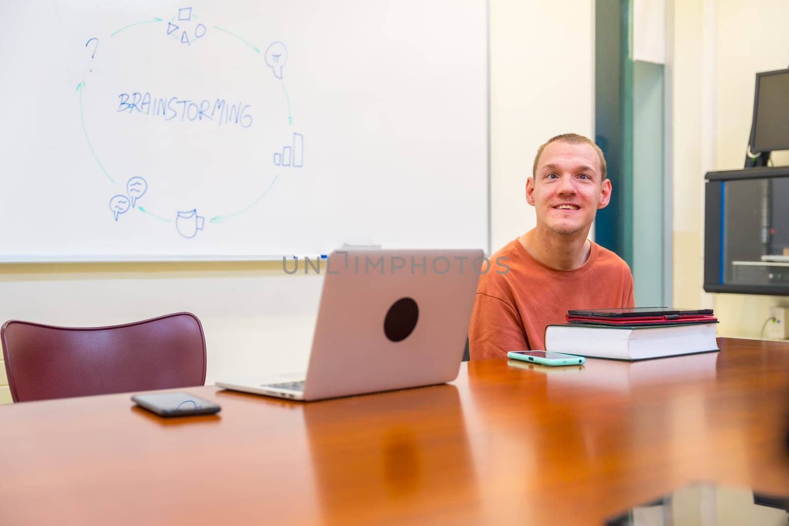 Horizontal photo with copy space of a caucasian disabled man sitting in an university meeting room