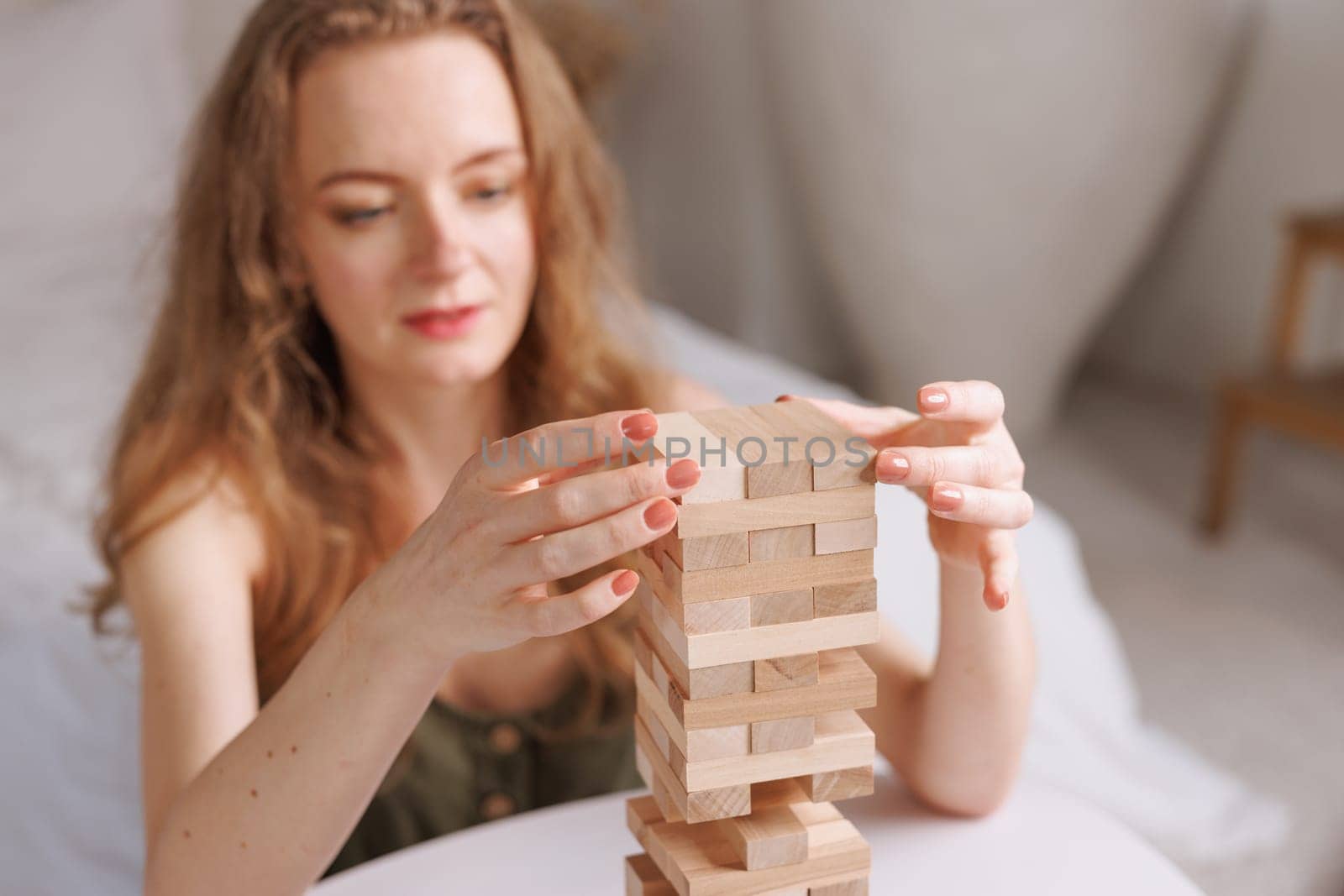 two women playing a board game made of wooden blocks at home, excitement and relaxation, mind development concept, hand motor skills,