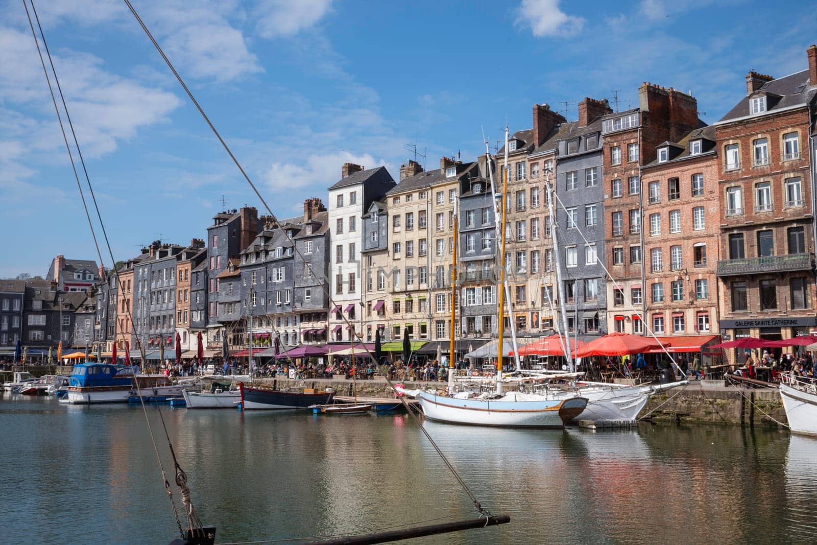 Honfleur, Normandy, France - 25-04-2024: People Sitting on the Terrace of the Restaurant. Port of Honfleur in the Calvados department in northwestern France