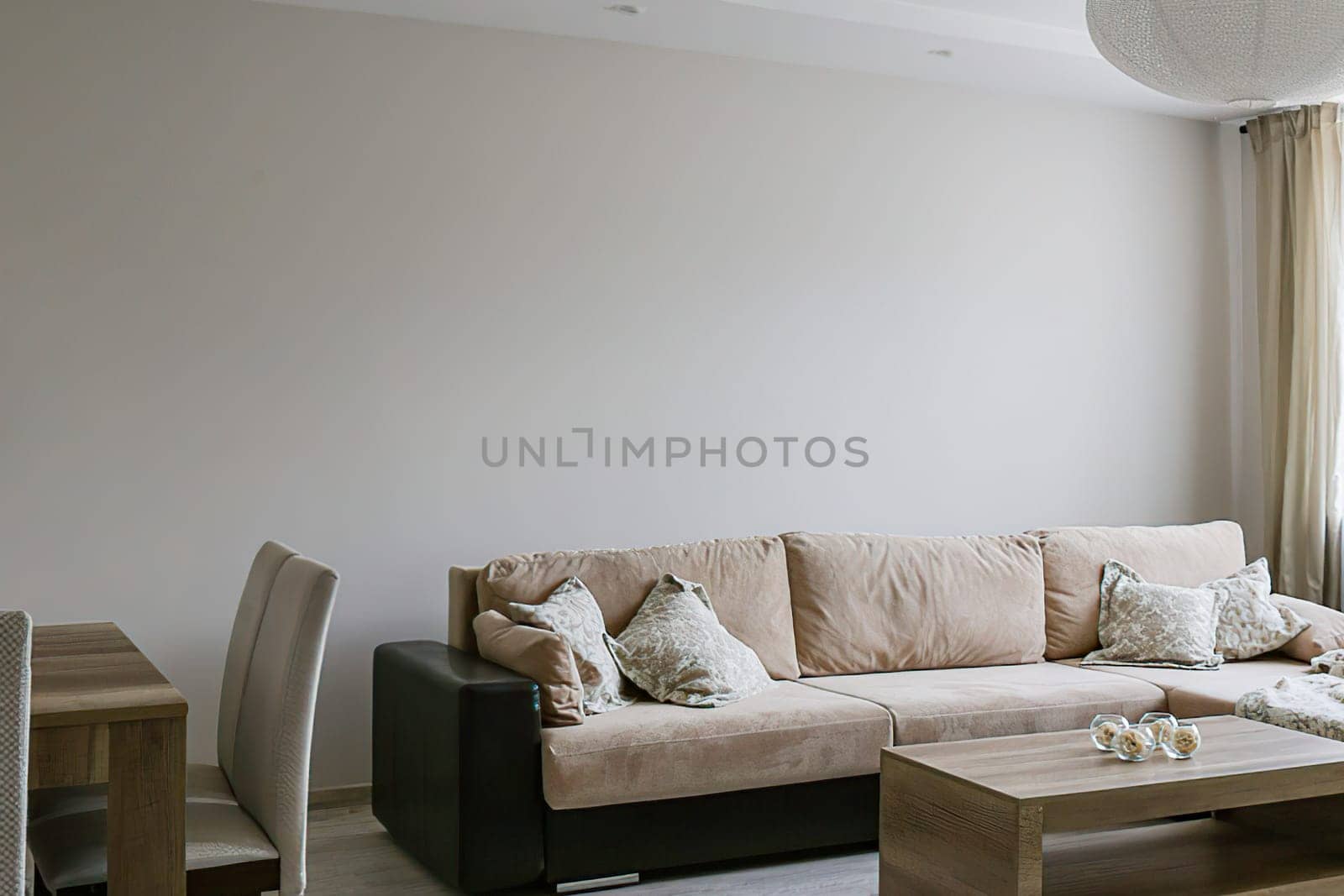 Living room with large sofa, pillows, coffee table, laminate flooring.