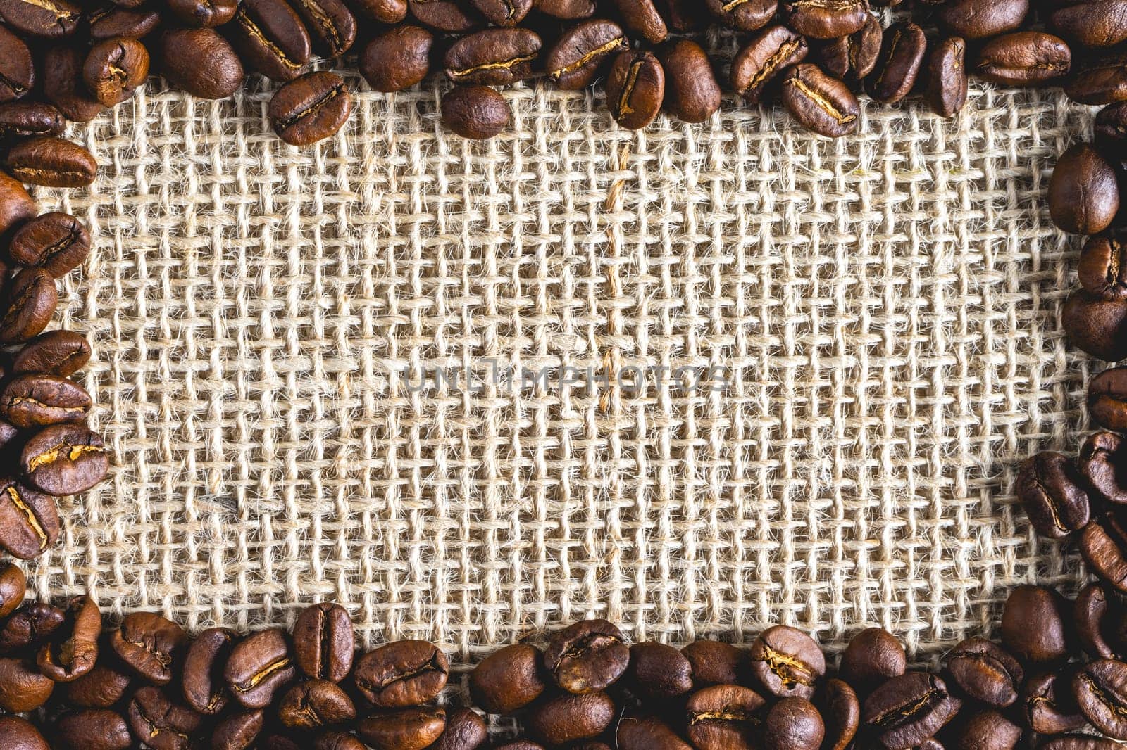 A frame of Coffee beans, on Burlap fabric. Background voor coffee related products.