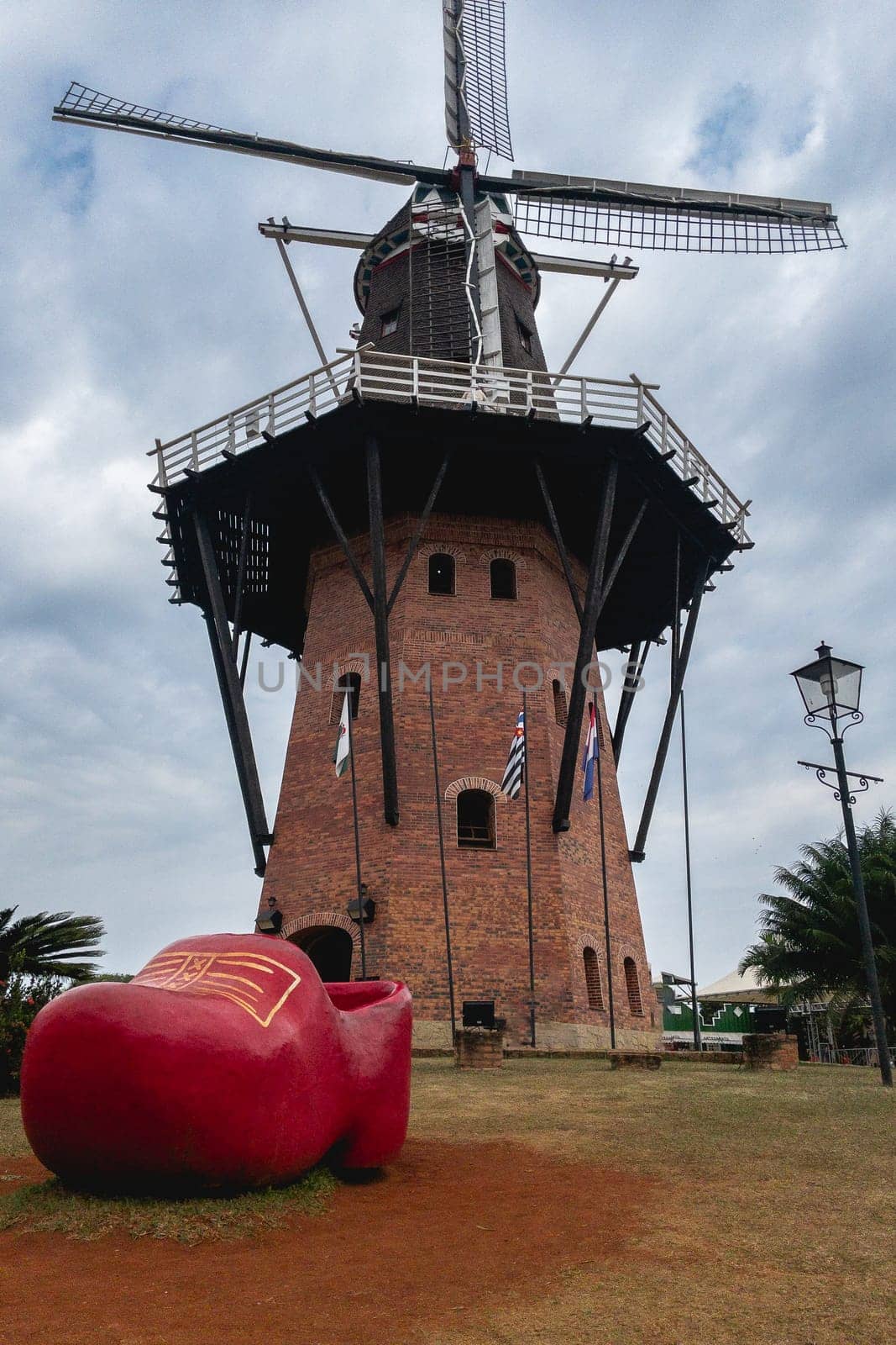 A dutch windmill with a dutch shoe in the foreground. touristic attraction in Holambra, SP Brazil. June 30, 2024.