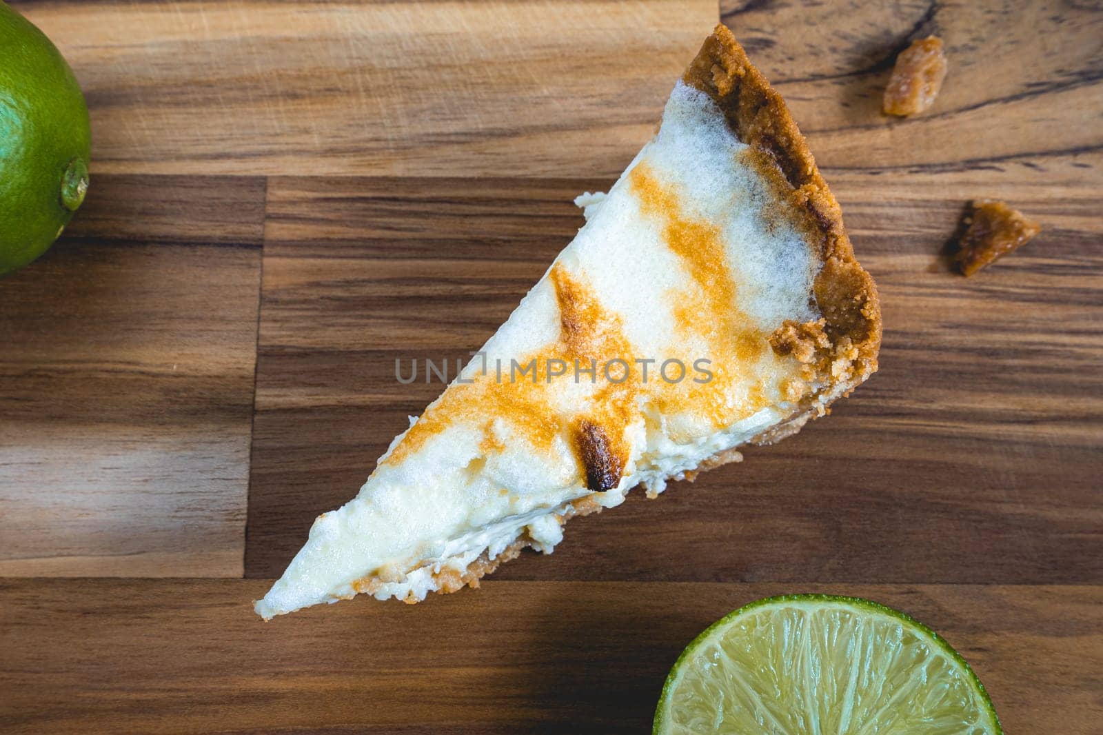 A home made Lemon pie, on a wooden plate. Decorated with lemons.