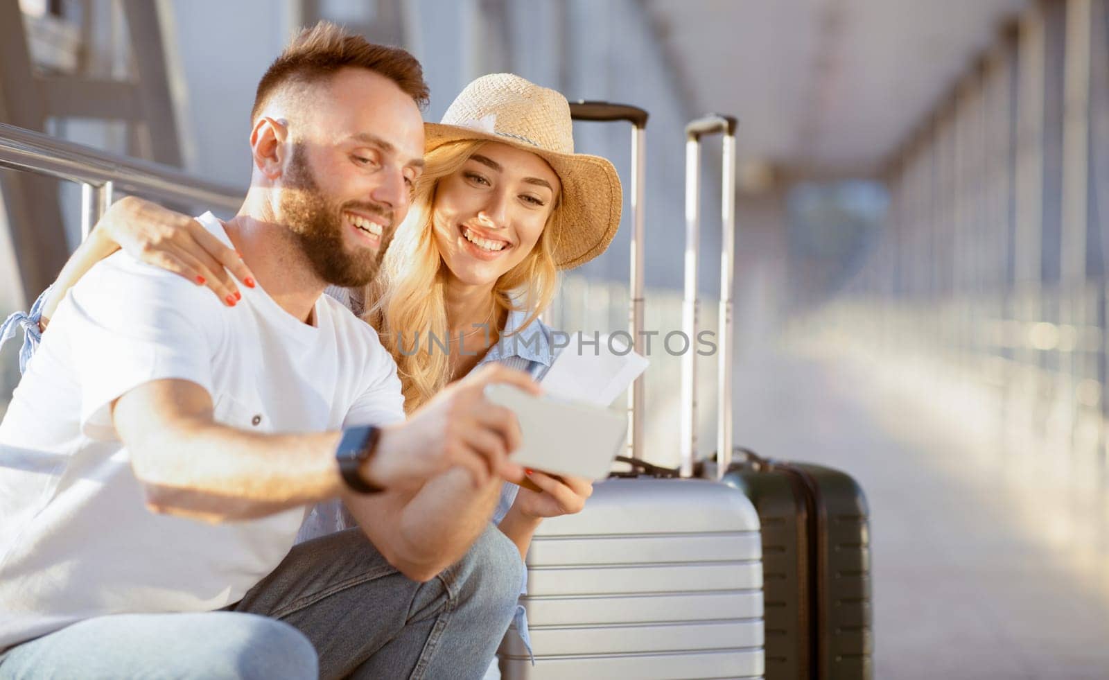 Vacation Begins. Happy couple taking selfie with tickets, waiting for a flight in the airport building