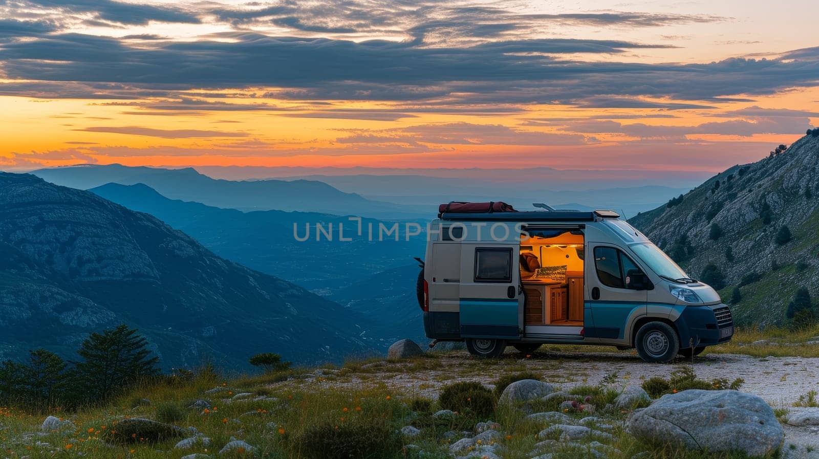 Camper van parked on a mountain at sunset with panoramic views of the valley