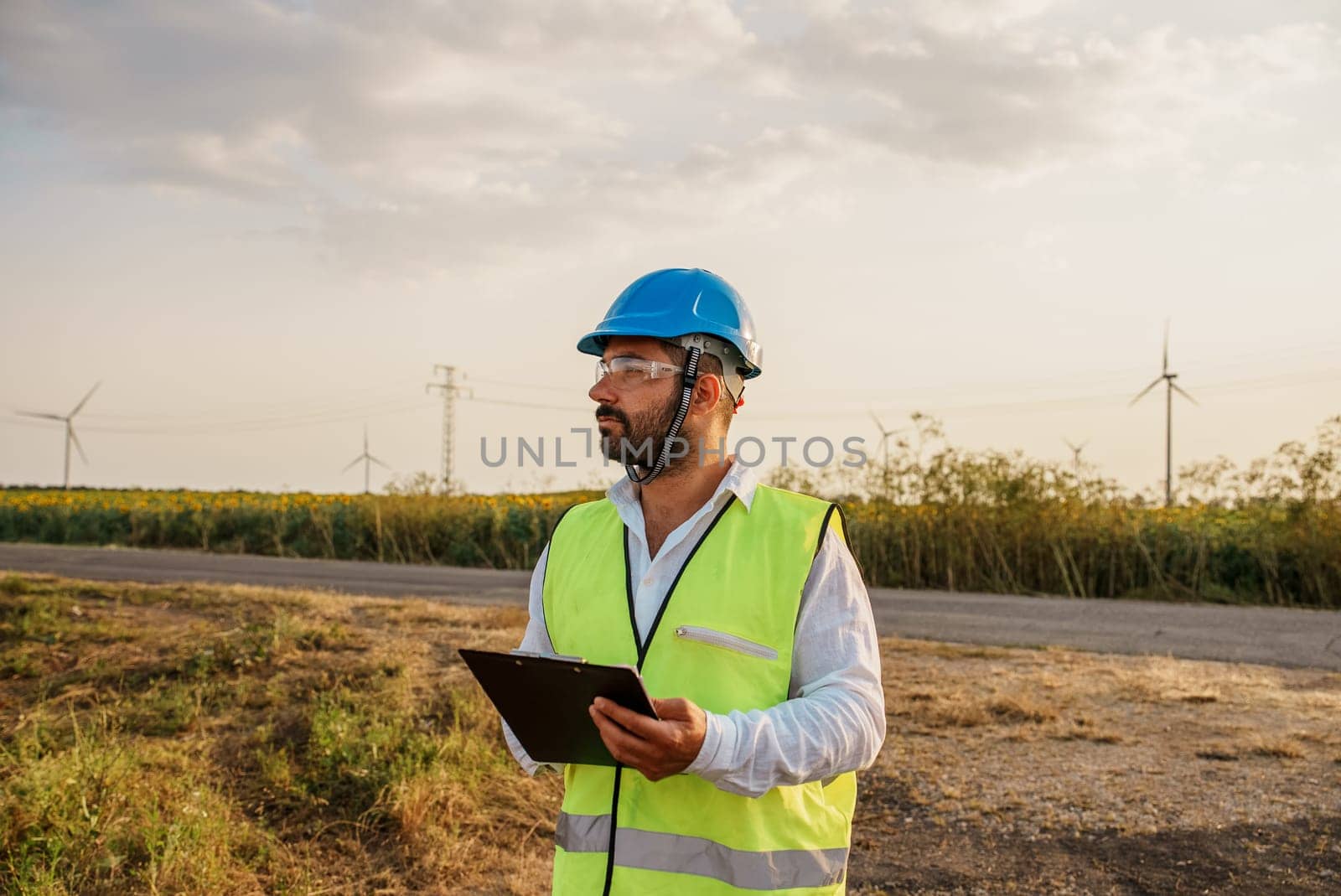 Male engineer cheking wind turbine farm energy generation. Wind turbine engineer at work