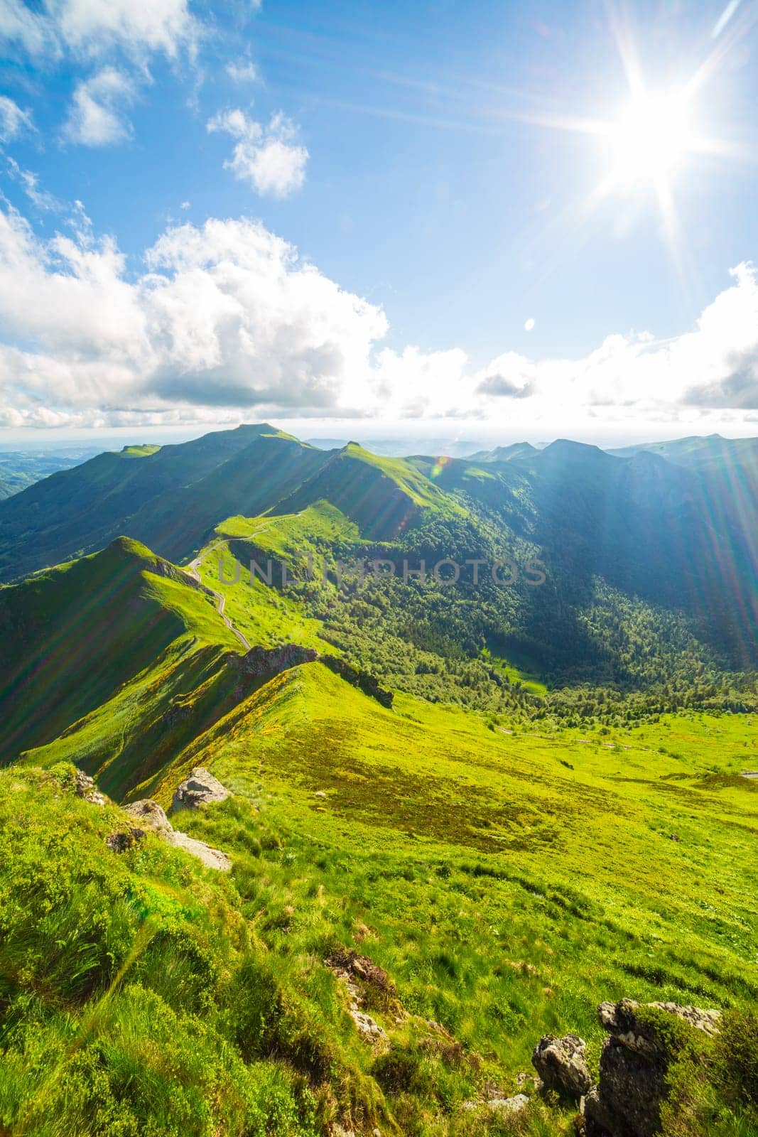 Vertical view of volcanic landscape and Puy Mary in summer. Backlit photograph taken in France