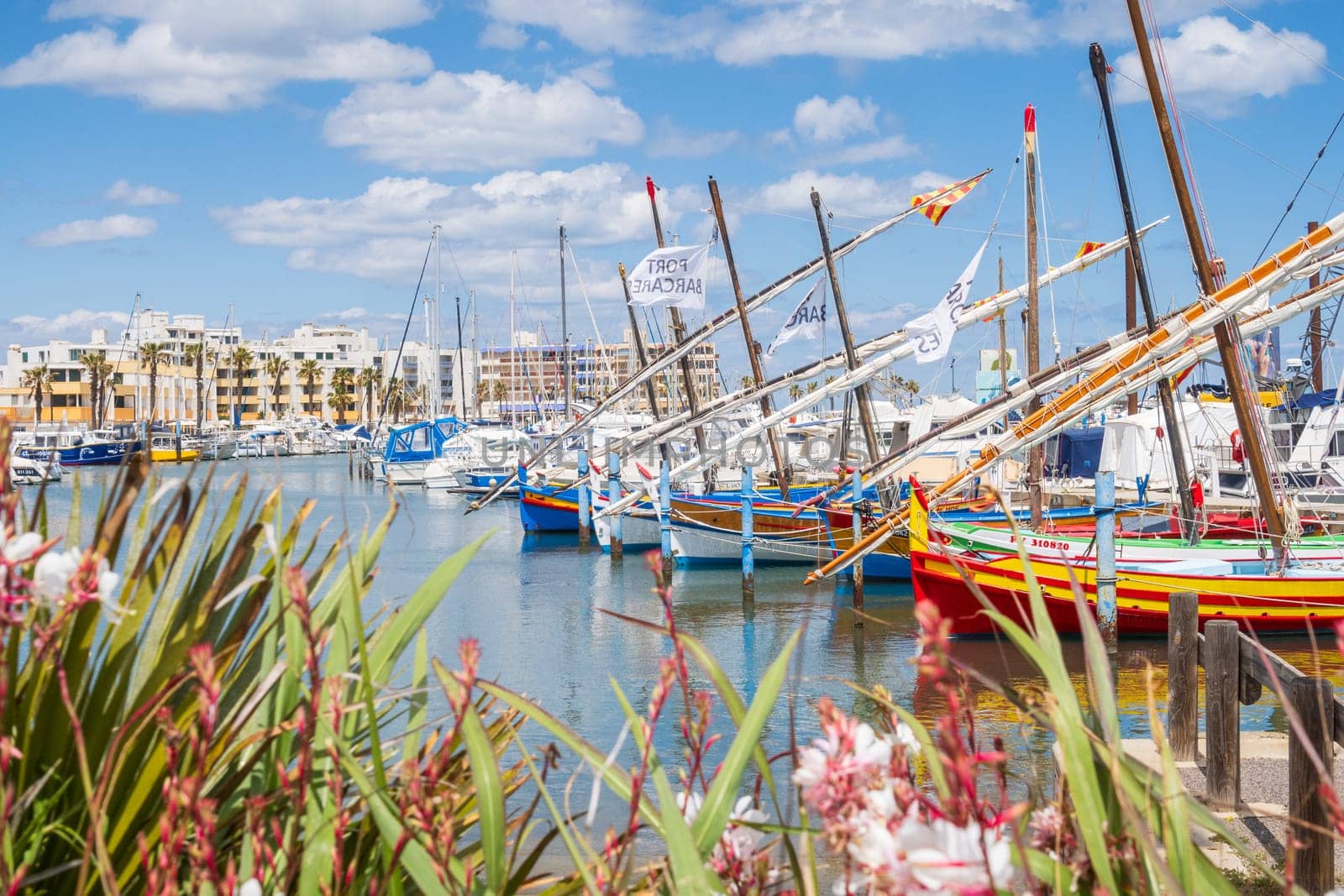 Le Barcarès, France - May 22, 2024: The fishing and marina port photographed in bright light and vivid colors. Fishing boats displayed in foreground