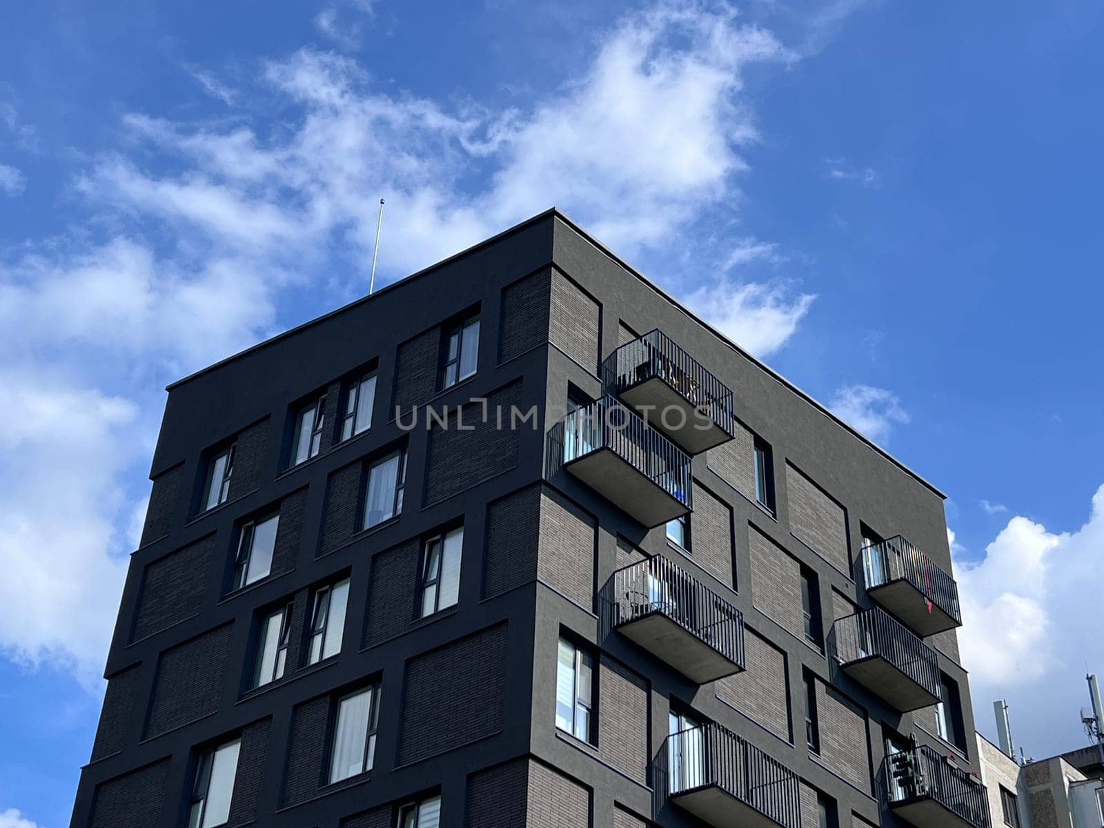 Many modern white cottages with panoramic windows on the background of the park and blue sky. High quality photo