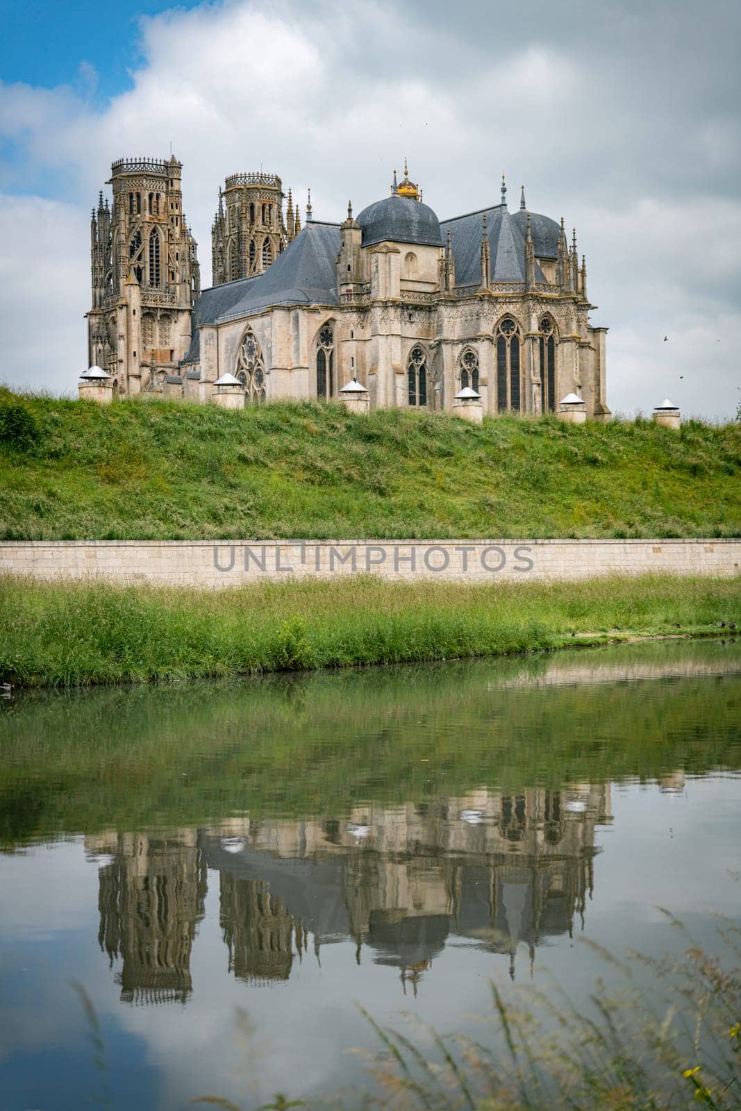 Distant view of the Cathedral of Toul from the bridge over the Moselle with the reflection in the river