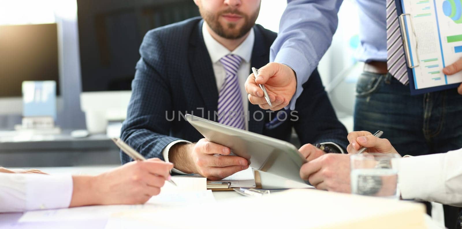 Group businessman are looking and studying statistics on tablet display closeup. Male hand opponent holds pen and points out problem collaboration business coach cooperation partnership palm concept