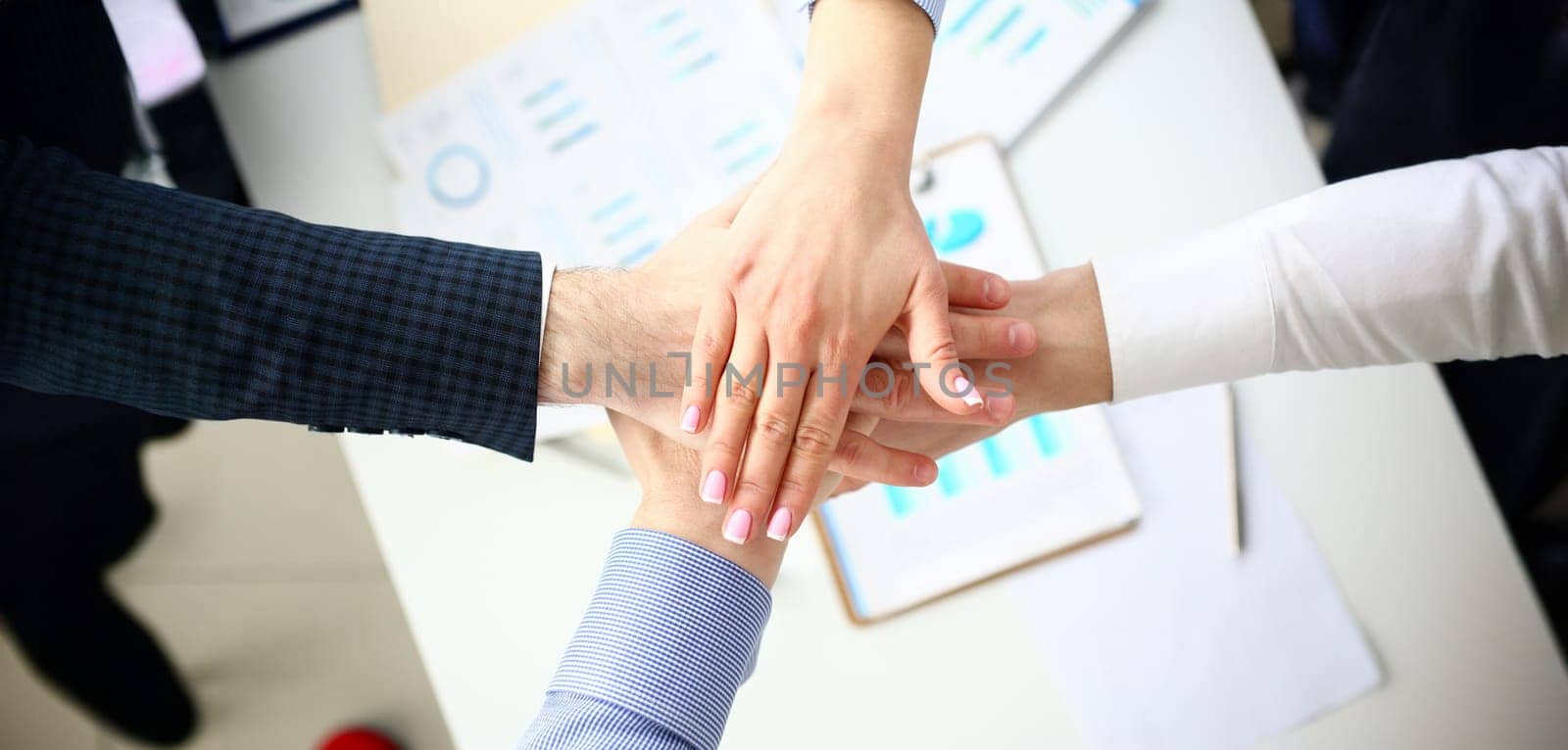 Group of people in suits crossed hands in pile for win closeup. White collar leadership high five cooperation initiative achievement corporate life style friendship dea, heap stack concept