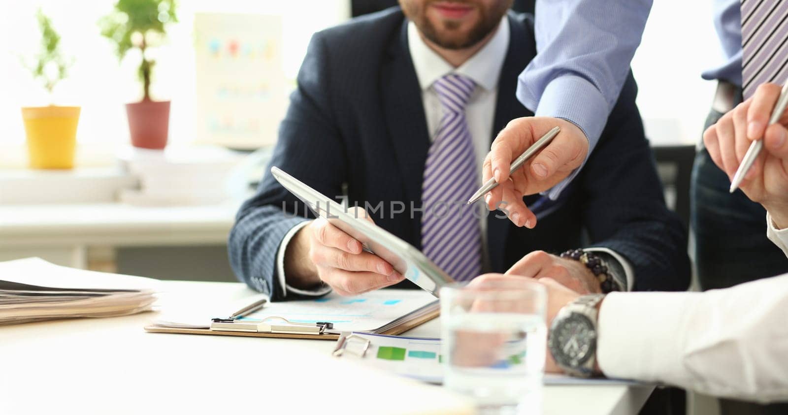 Group businessman are looking and studying statistics on tablet display closeup. Male hand opponent holds pen and points out problem collaboration business coach cooperation partnership palm concept