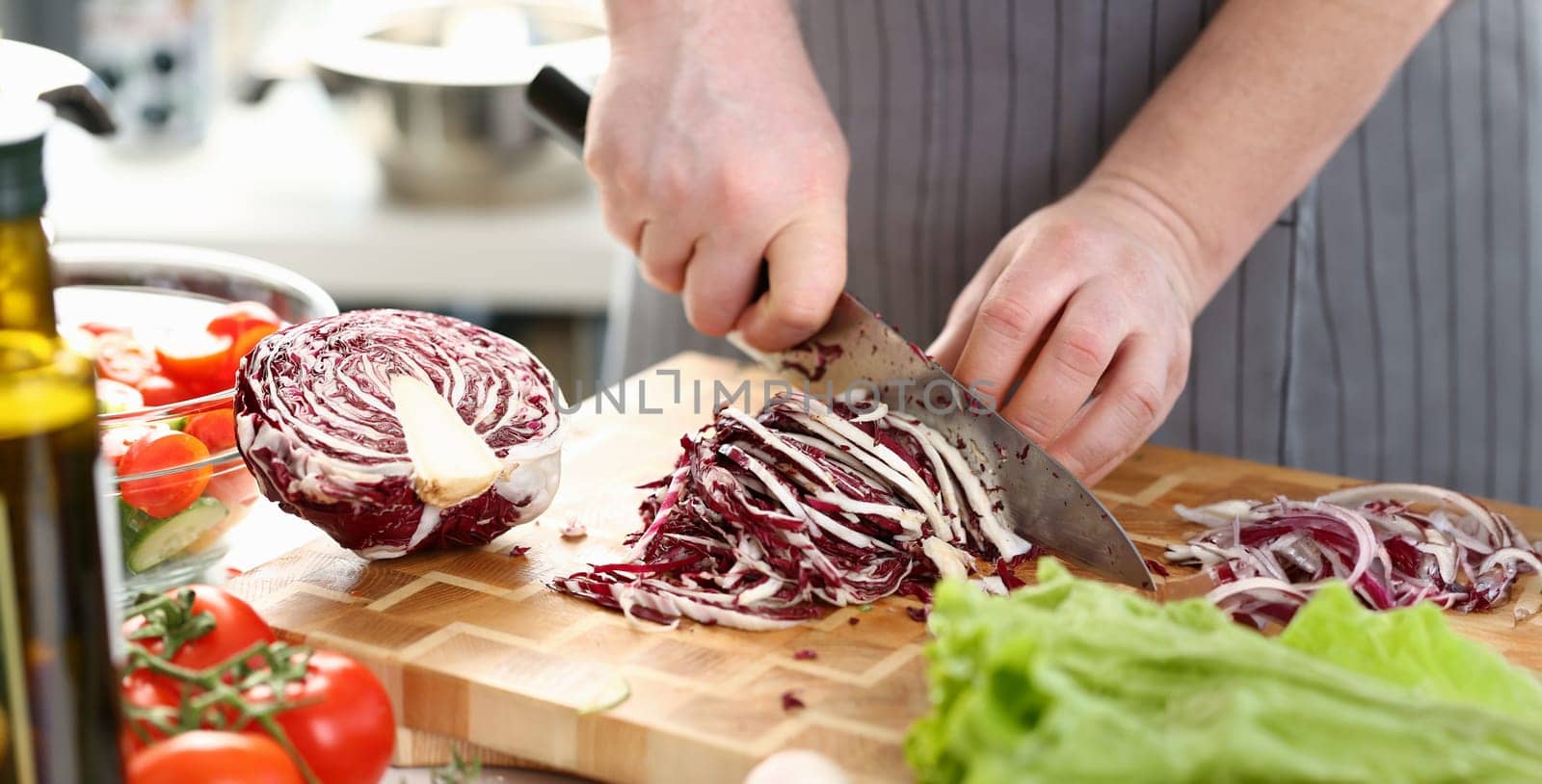 Chef Hands Slicing Purple Salad Cabbage Halve. Male Chopping Red Cole on Cutting Board in Kitchen at Home. Healthy Grocery Culinary Recipe. Fresh Dieting Ingredient Horizontal Photography
