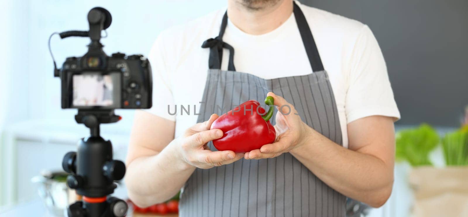 Male Hands Recording Pepper Culinary Recipe Blog. Chef Blogger Showing Red Vegetable Ingredient to Camcorder. Natural Vegetarian Culinary in Kitchen at Home. Organic Food Horizontal Photography
