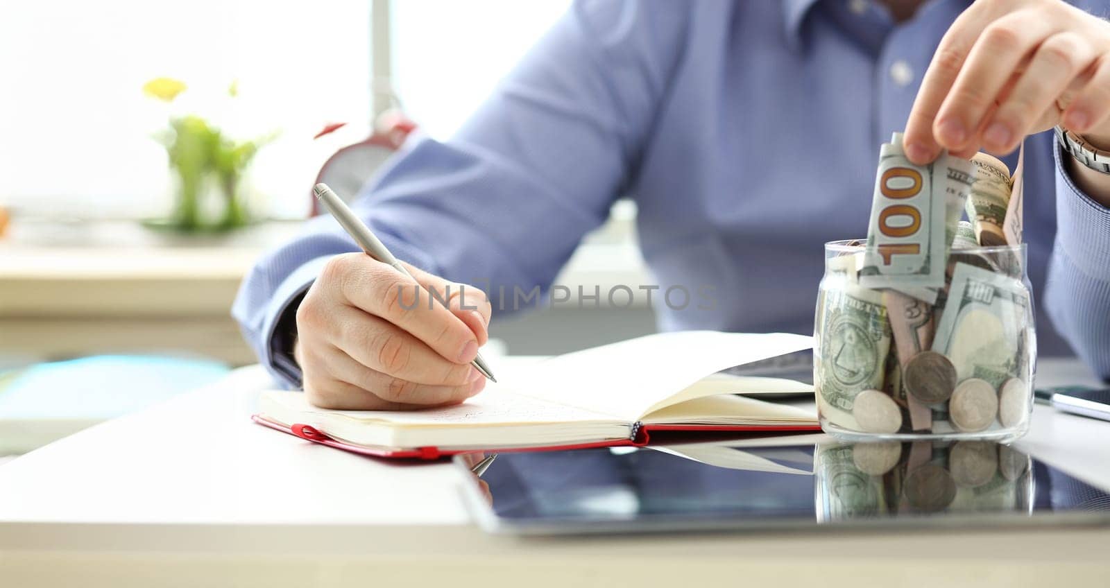 Male hand depositing some extra money in future needs closeup