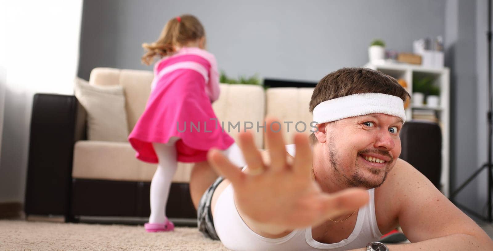 Cute little girl hold her father leg as proof of winning battle game portrait