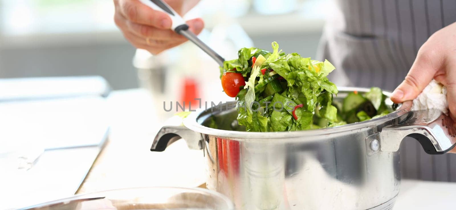 Male Hands Mixing Organic Chopped Vegetable Salad. Chef Cooking Dish with Lettuce, Tomato and Cucumber in Saucepan. Healthy Dieting Food Ingredient. Home Culinary Recipe Horizontal Photography