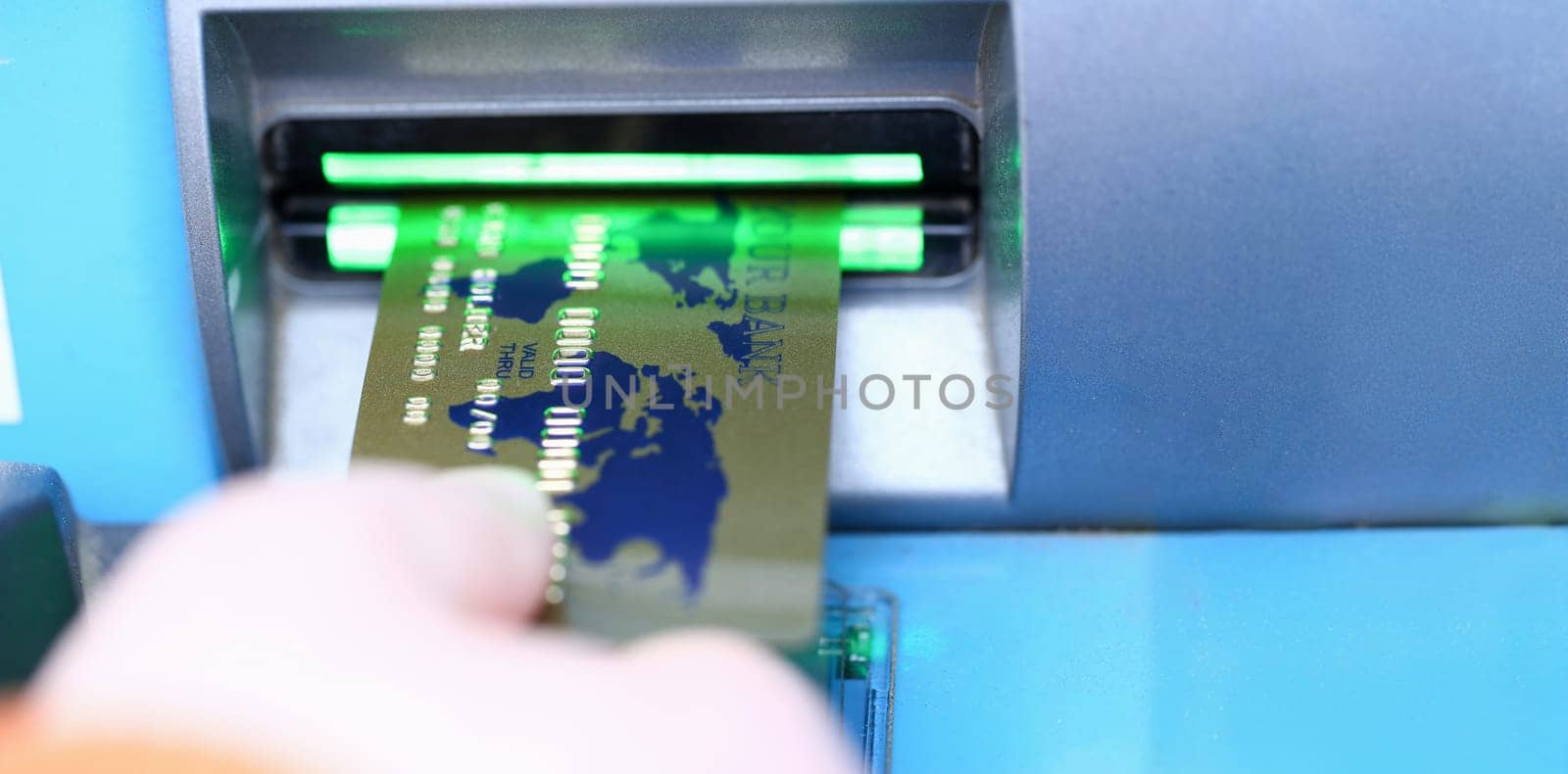 Male hand hold bank plastic card aganist atm background. Cash money payment system concept.