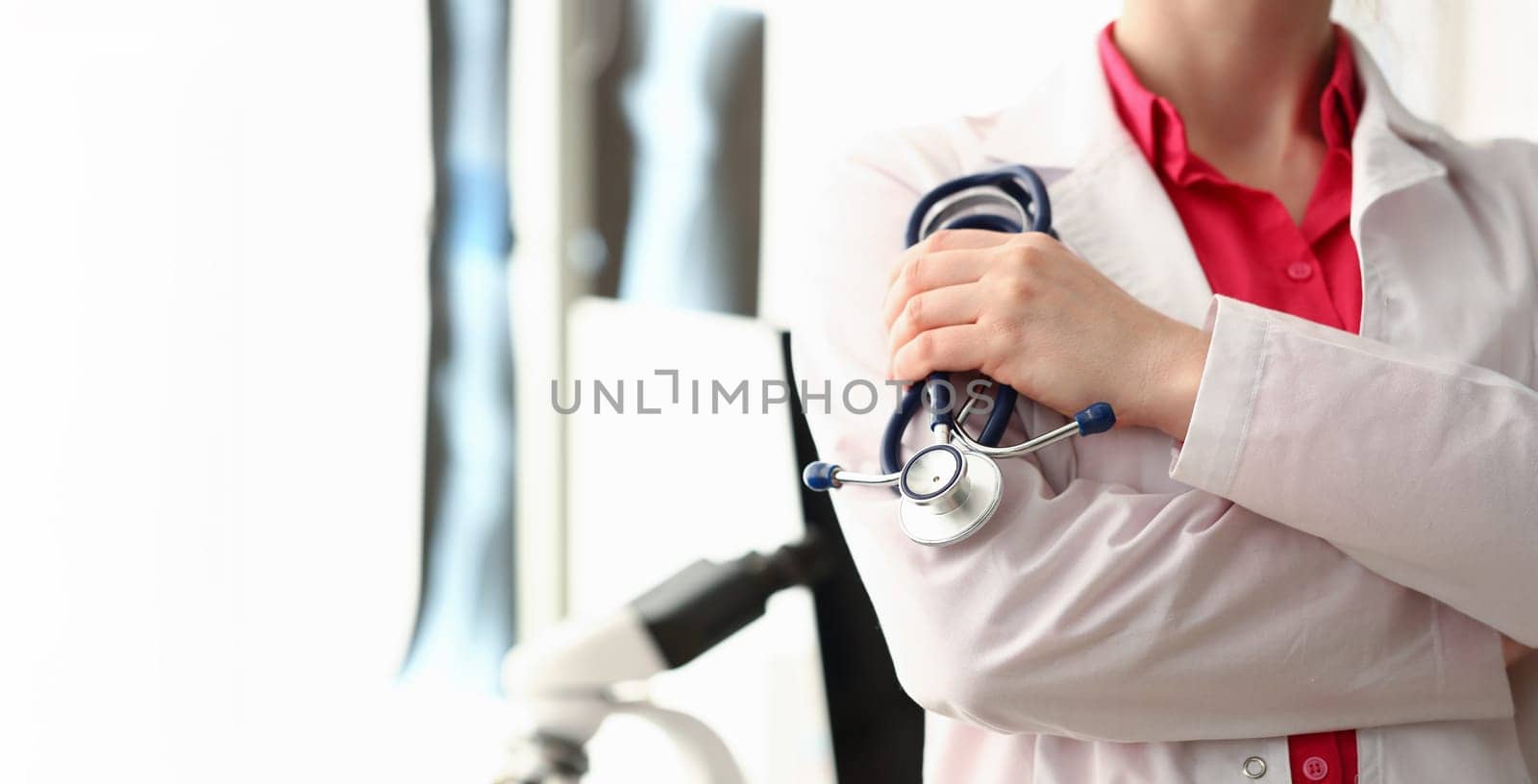 Female doctor hold stethoscope aganist clinic x-ray lab .background. Medical education healthcare concept.