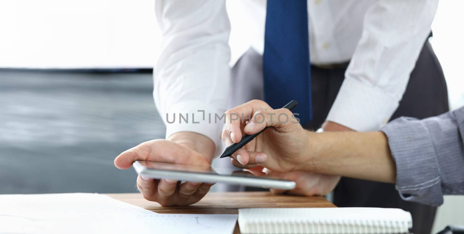 Focus on colleagues hands holding modern tablet and stylos. Businessmen discussion new biz project. Designers creating start-up. Creative work concept. Blurred background