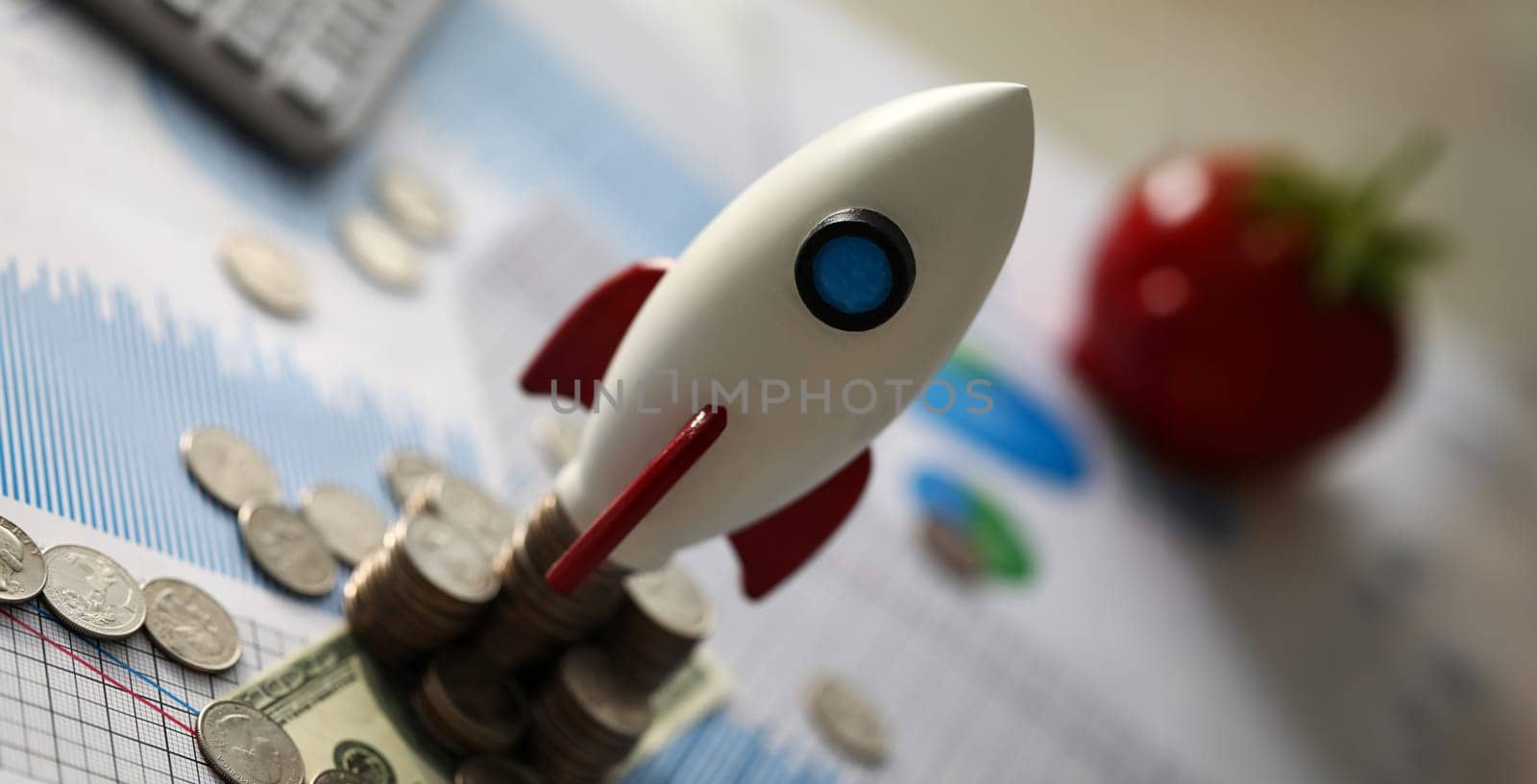 Focus on golden metallic currency lying on scattered sheets of important charts and graphs used to analyze profitable business corporation investment forwarding movements. Reports sale concept