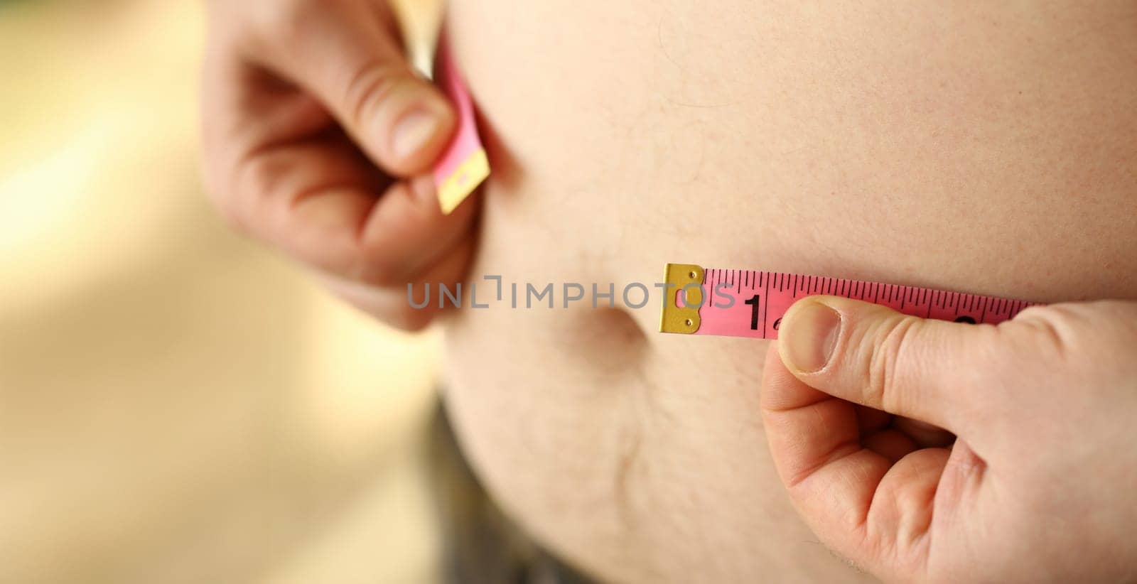 Thick man measuring belly with measuring tape. Concept of weight loss, dieting and healthy lifestyle. Figure of overweight person.