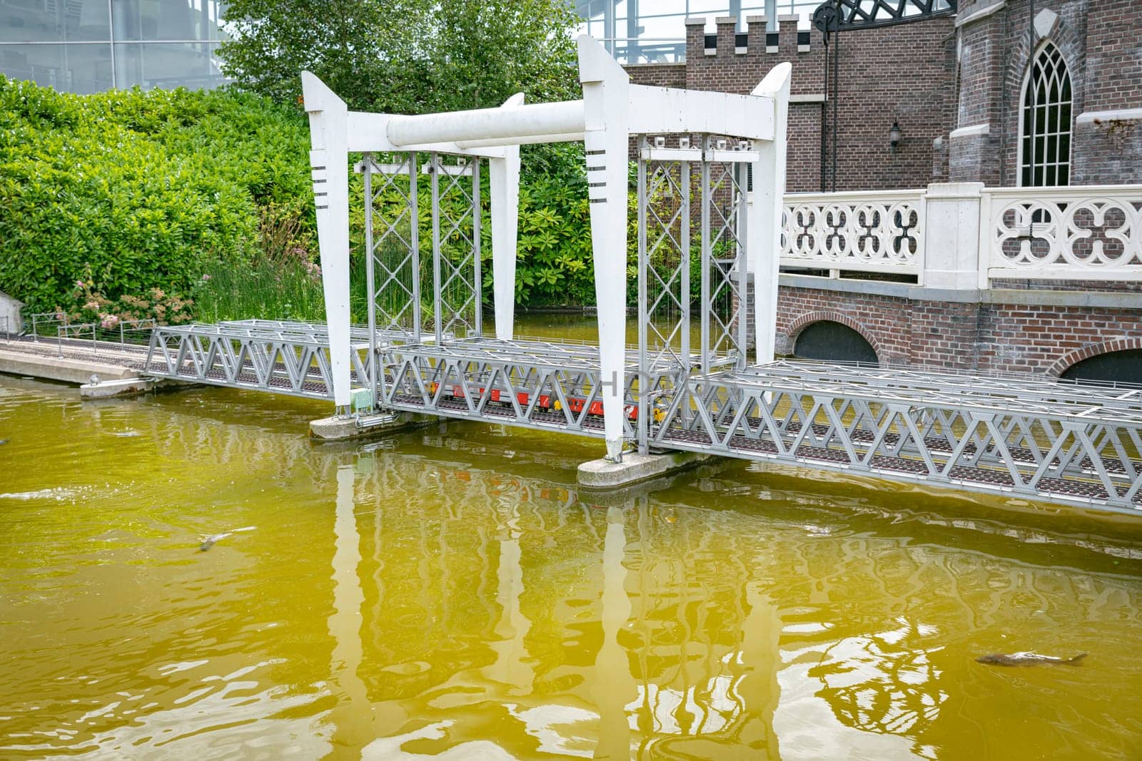 the haque,holland,09-07-2024:Toy dutch post train over the bridge over the river in a miniature city in Madurodam park, Netherlands.