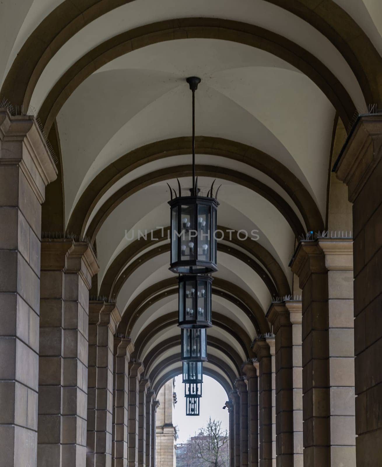 Munich, Germany - Dec 21, 2023 - Perspective view of Stone archway walkway with lanterns outside the ballroom of the The Munich Residence building. Architectural structure in Renaissance baroque style, Copy space, Selective focus.