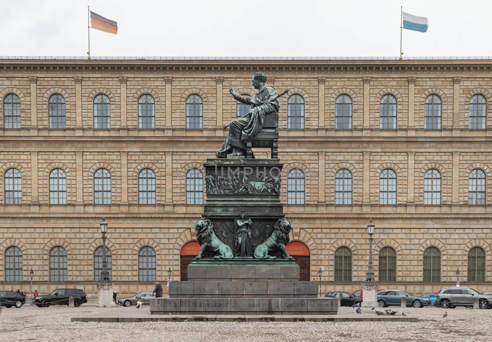 Munich, Germany - Dec 21, 2023 - Side view of Monument Bronze Statue of King Maximilian I Joseph of Bavaria with The Munich Residence Museum Building at the Max Joseph Square in central Munich. Space for text, Selective focus.