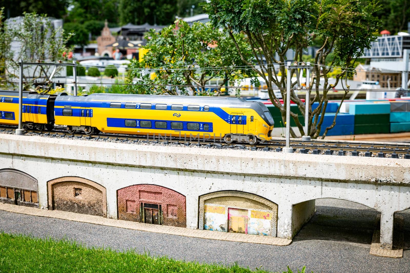 the haque,holland,09-07-2024:Toy dutch train over the bridge over the river in a miniature city in Madurodam park, Netherlands.