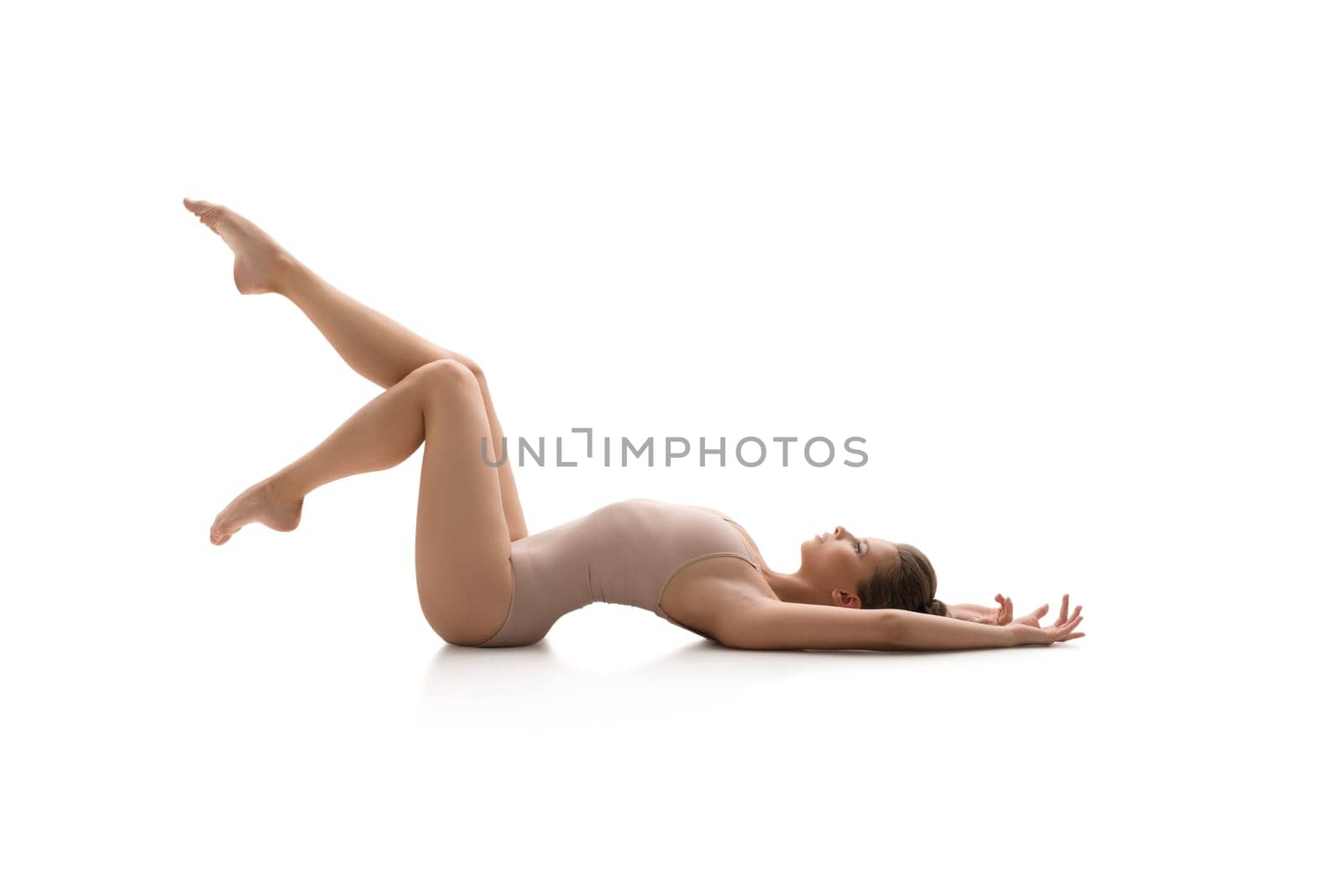 Young female gymnast in sports beige body doing acrobatics together in studio