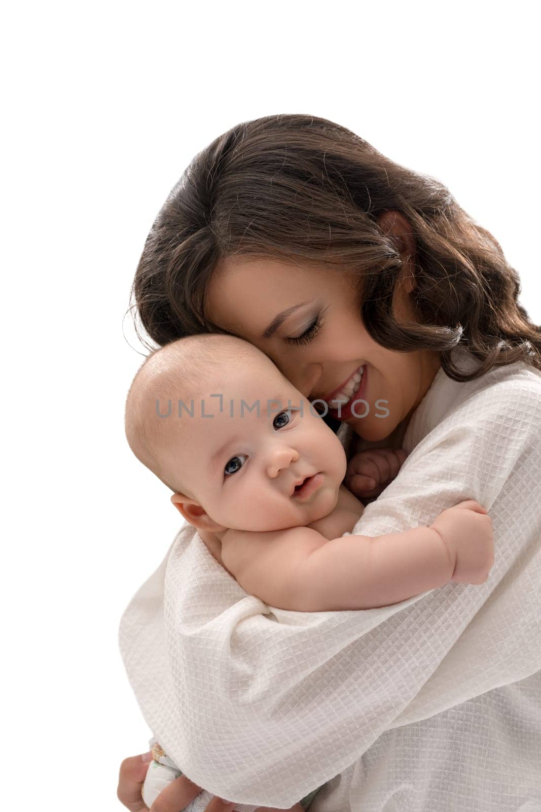 Young pretty mother keeping lovely baby boy in her arms smiling affectionately at him studio shot
