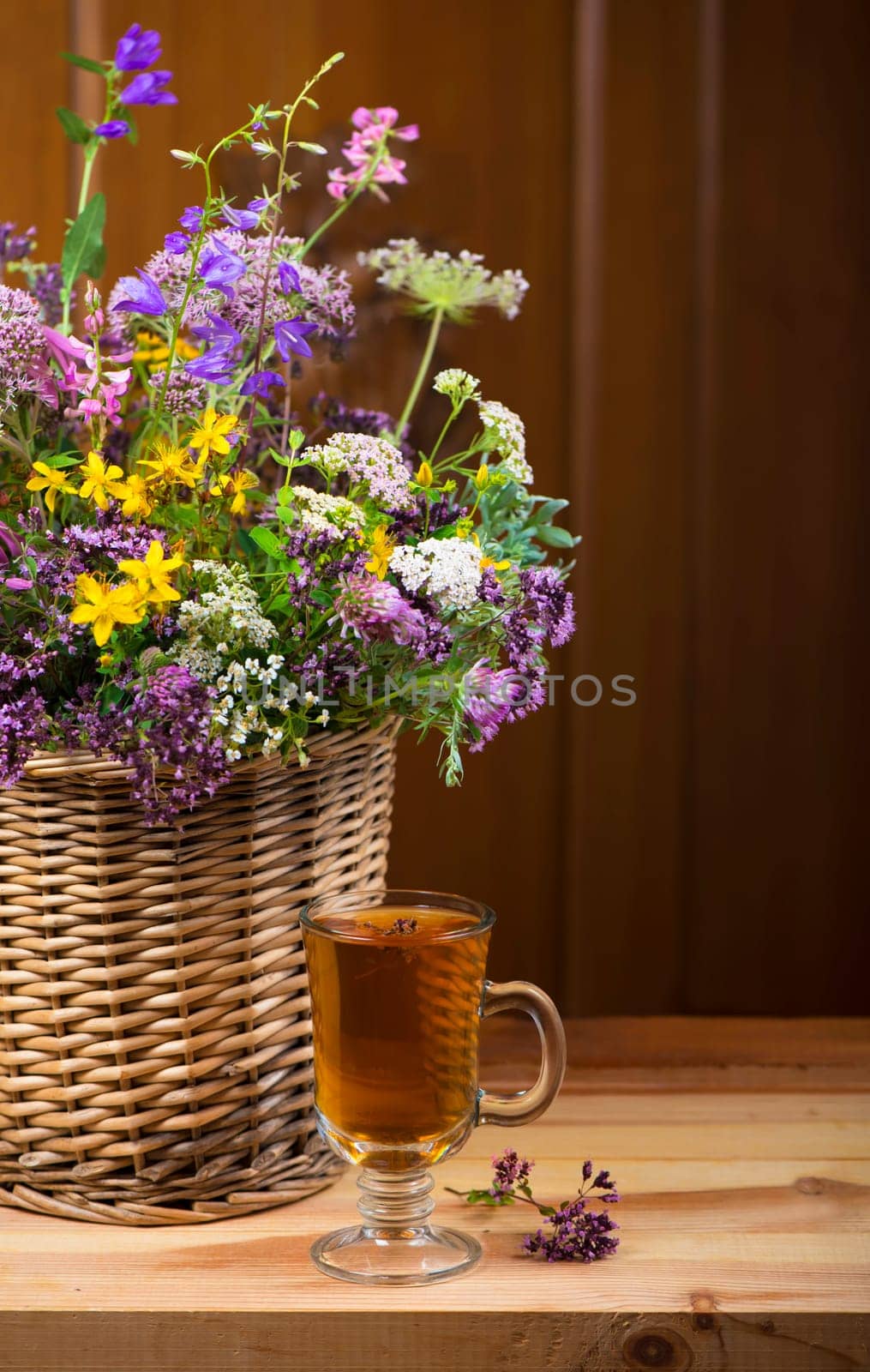 Bouquet of medicinal herbs in basket and herbal tea by aprilphoto