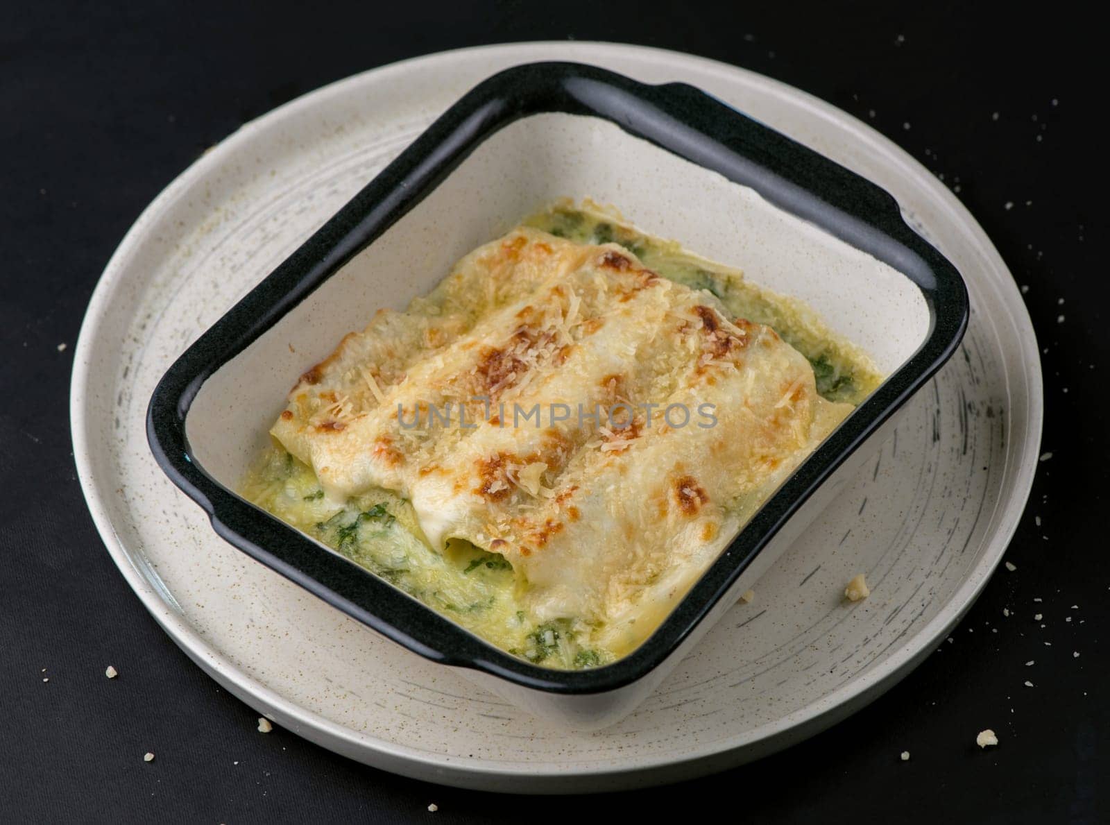 Lasagna with spinach. Homemade Italian lasagna with spinach chicken. Dark background. by aprilphoto