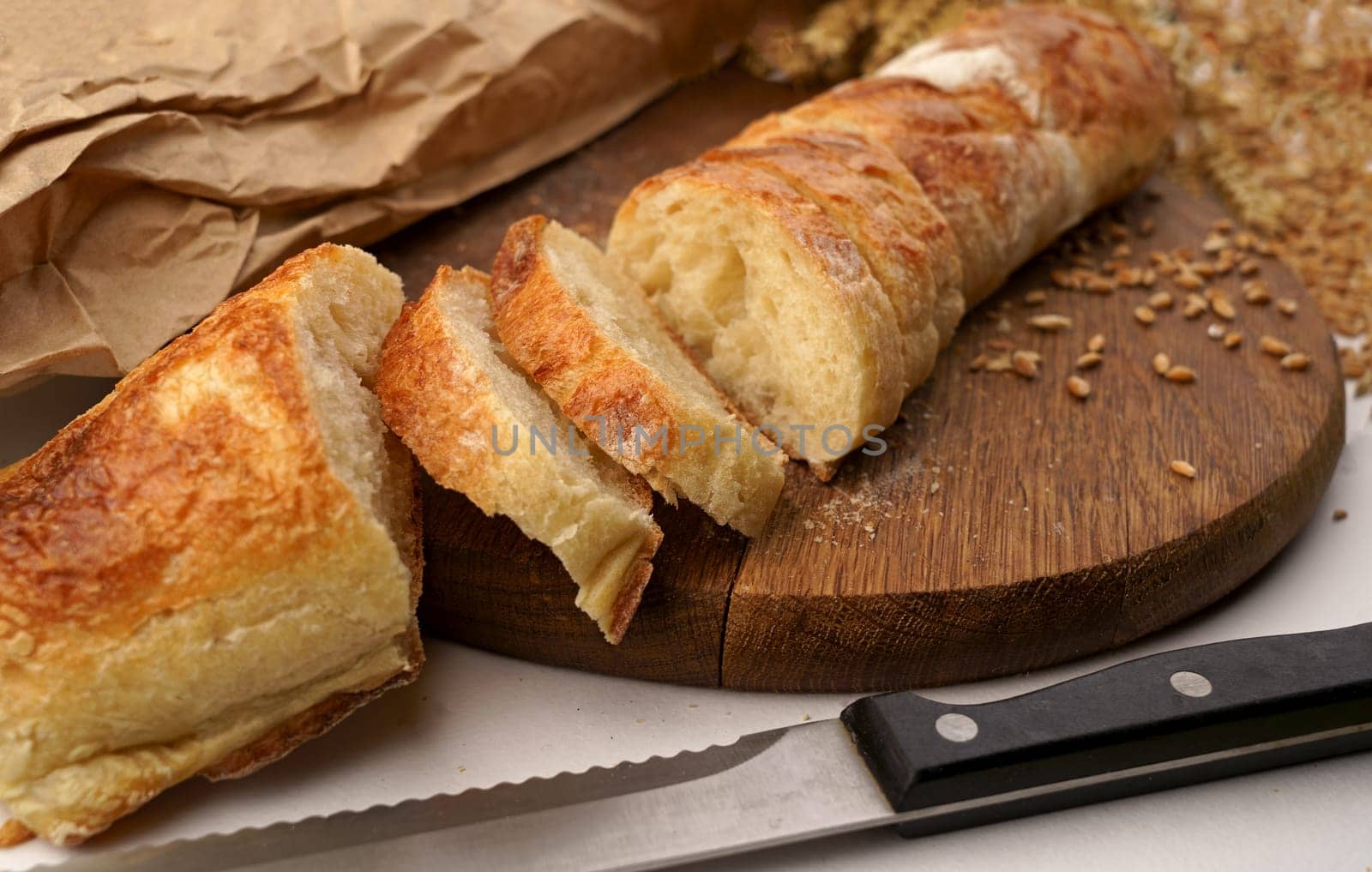 Slicing French Baguette On Slice For Bruschetta. Cutting Bread On Kitchen. Making Morning Breakfast. Fresh Bread On Table. Cutting French Baguette.