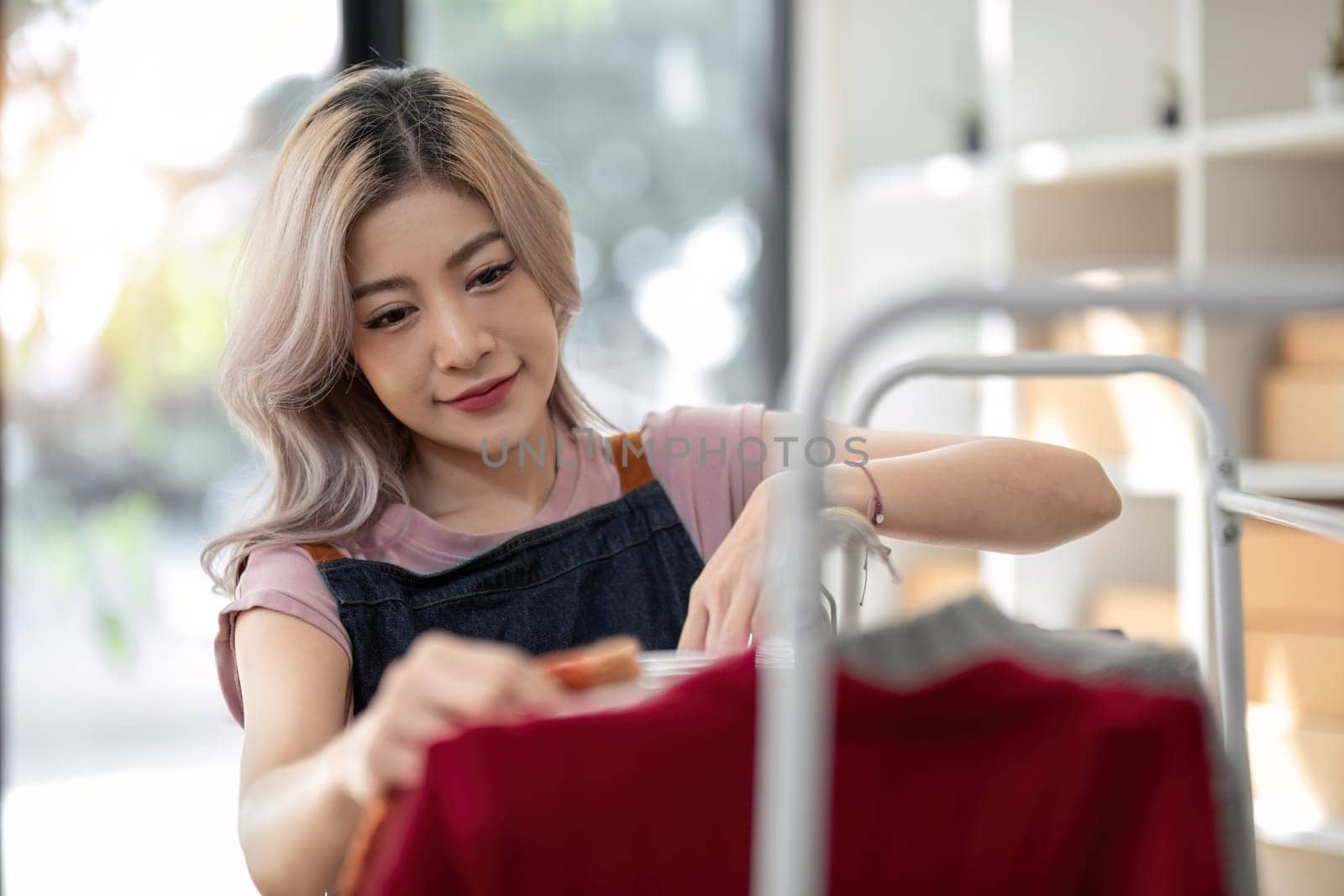Small business owner, woman asia beautiful entrepreneur, seller checking ecommerce clothing store orders working in her office. Online sales by wichayada